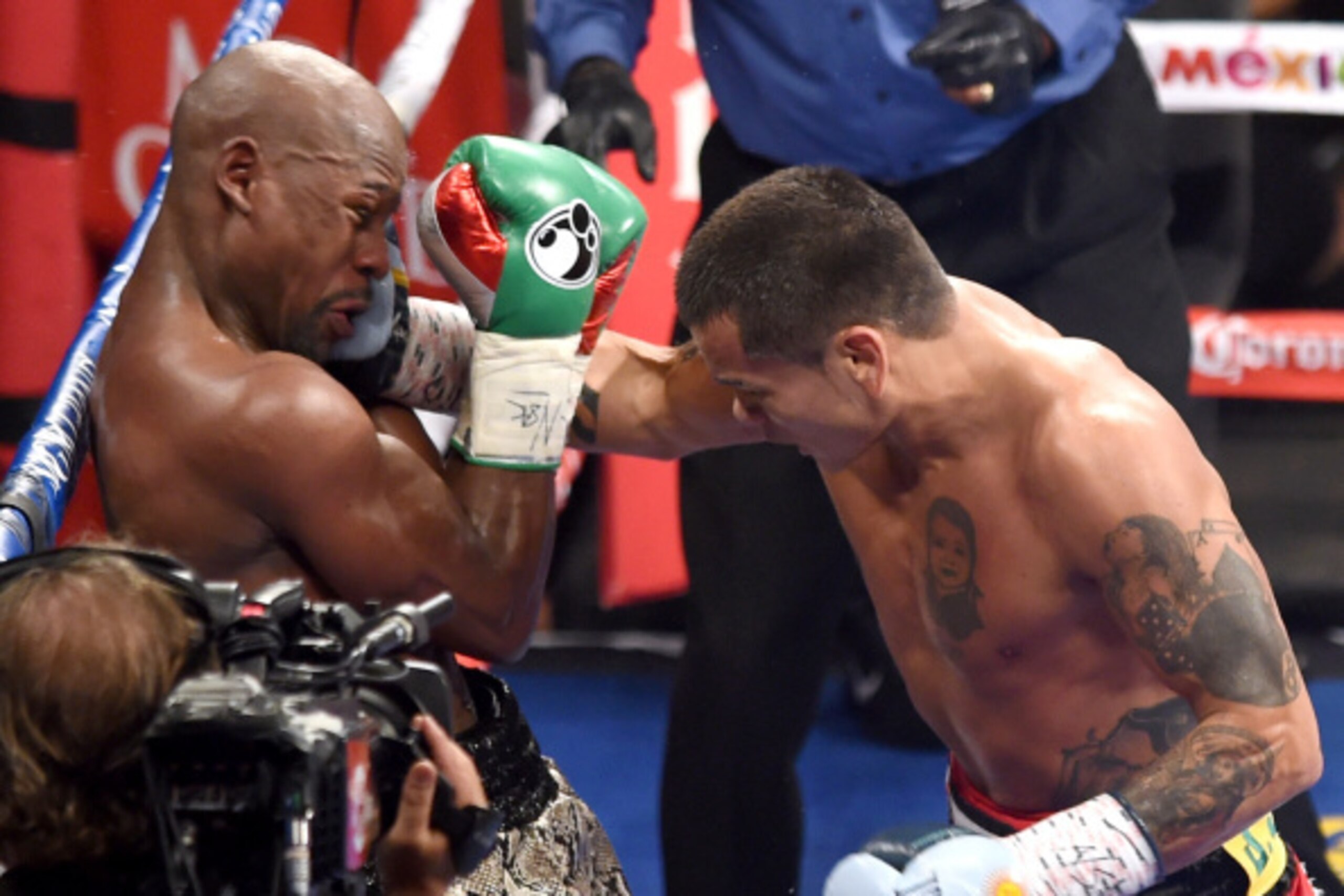 LAS VEGAS, NV - SEPTEMBER 13:  Marcos Maidana (R) hits Floyd Mayweather Jr. with a right in the fourth round of their WBC/WBA welterweight title fight at the MGM Grand Garden Arena on September 13, 2014 in Las Vegas, Nevada. Mayweather Jr. won by unanimou