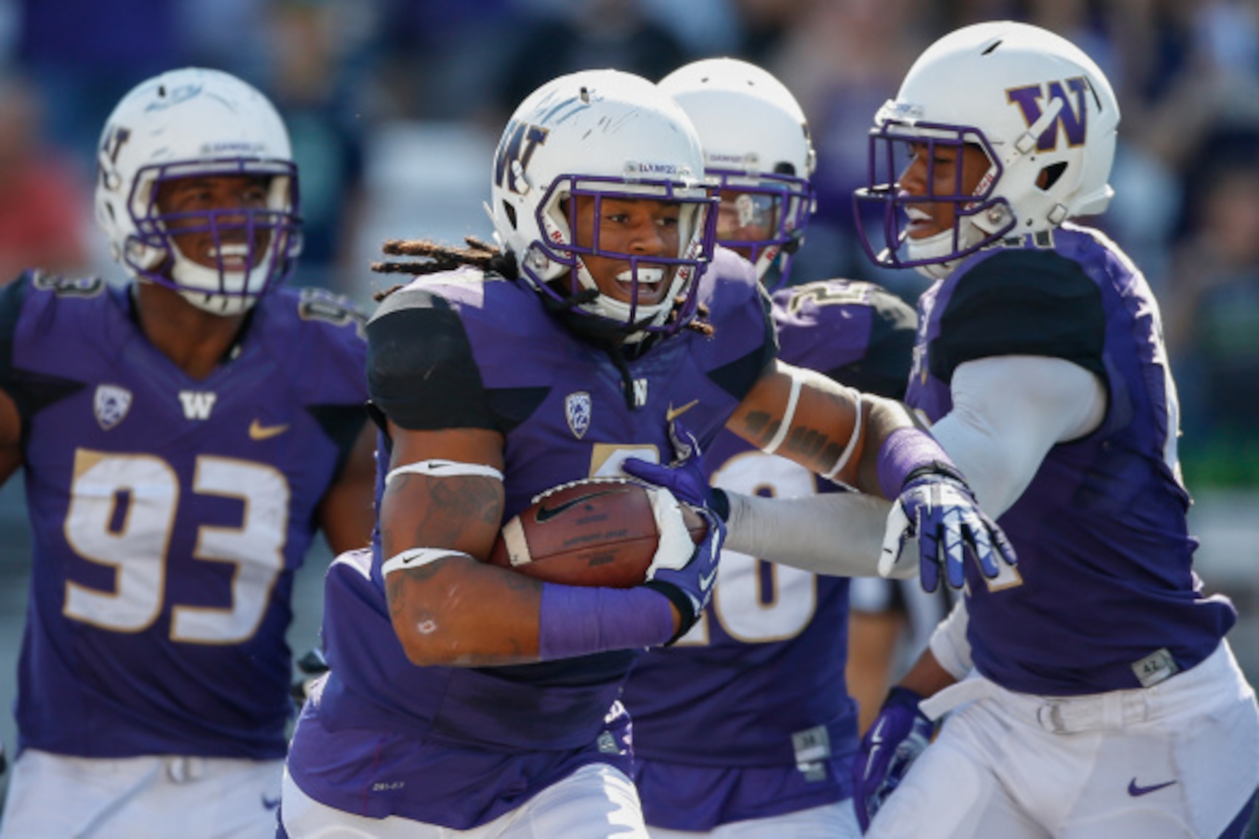 SEATTLE, WA - SEPTEMBER 13: Linebacker Shaq Thompson #7 (with ball) of the Washington Huskies is congratulated by teammates after returning an interception for a touchdown in the first quarter against the Illinois Fighting Illini on September 13, 2014 at 