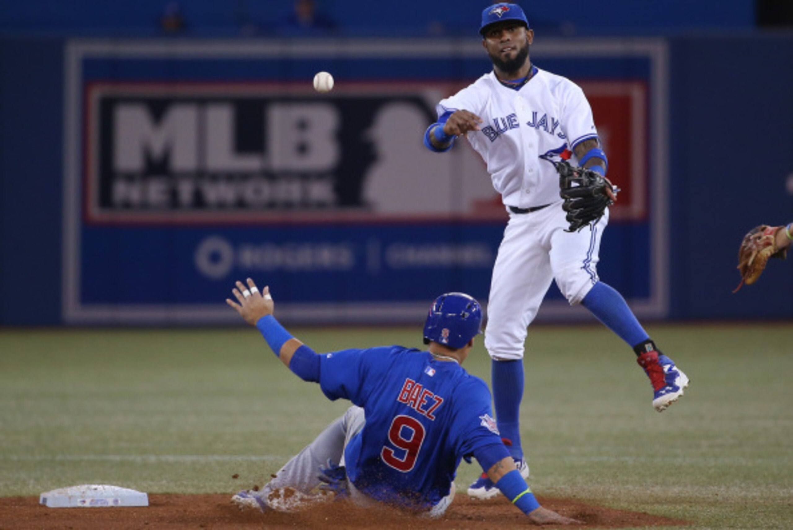 TORONTO, CANADA - SEPTEMBER 9: Jose Reyes #7 of the Toronto Blue Jays turns a double play in the third inning during MLB game action as Javier Baez #9 of the Chicago Cubs slides into second base on September 9, 2014 at Rogers Centre in Toronto, Ontario, C
