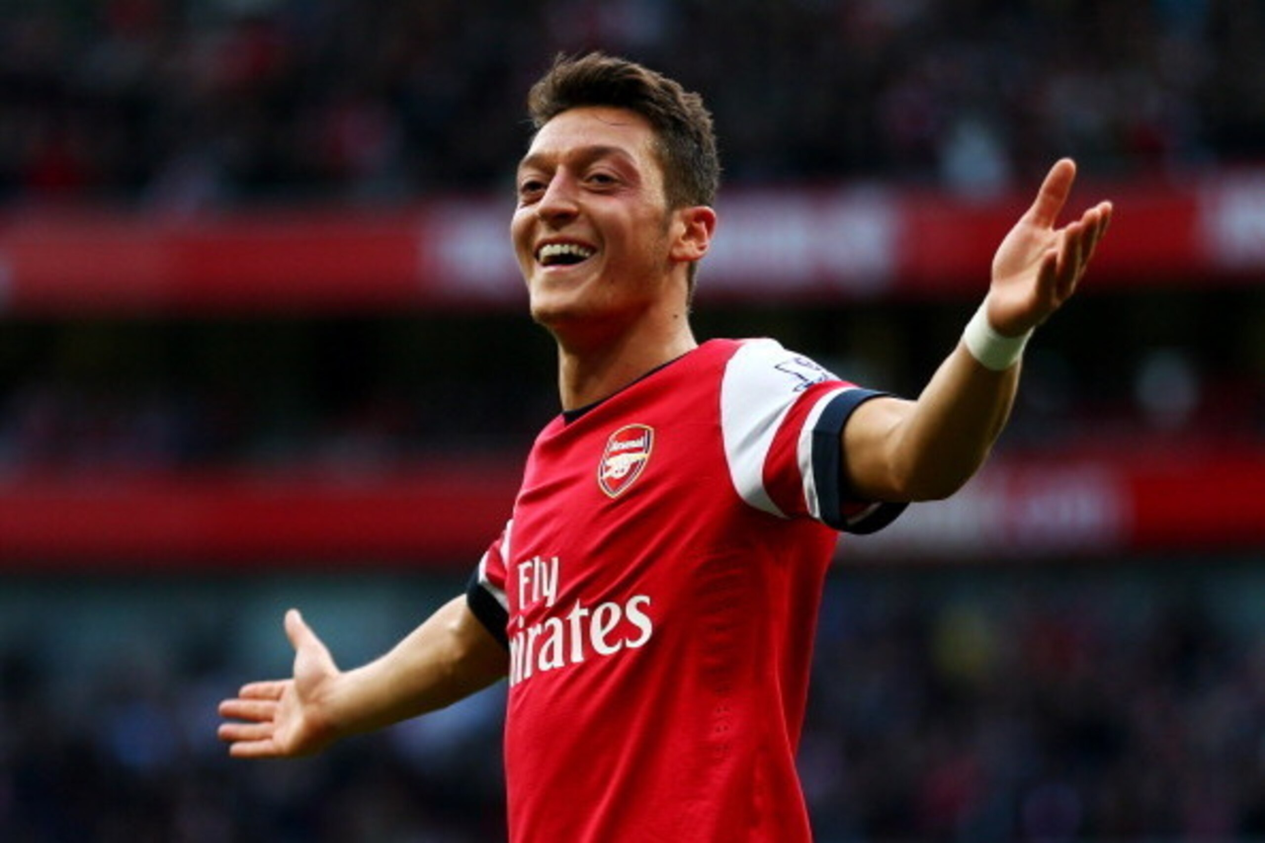 LONDON, ENGLAND - OCTOBER 19:  Mesut Oezil of Arsenal celebrates as he scores their second goal during the Barclays Premier League match between Arsenal and Norwich City at Emirates Stadium on October 19, 2013 in London, England.  (Photo by Paul Gilham/Ge