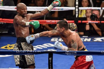 LAS VEGAS, NV - SEPTEMBER 13:  Floyd Mayweather Jr. (L) avoids a right by Marcos Maidana in the 10th round of their WBC/WBA welterweight title fight at the MGM Grand Garden Arena on September 13, 2014 in Las Vegas, Nevada. Mayweather Jr. won by unanimous 