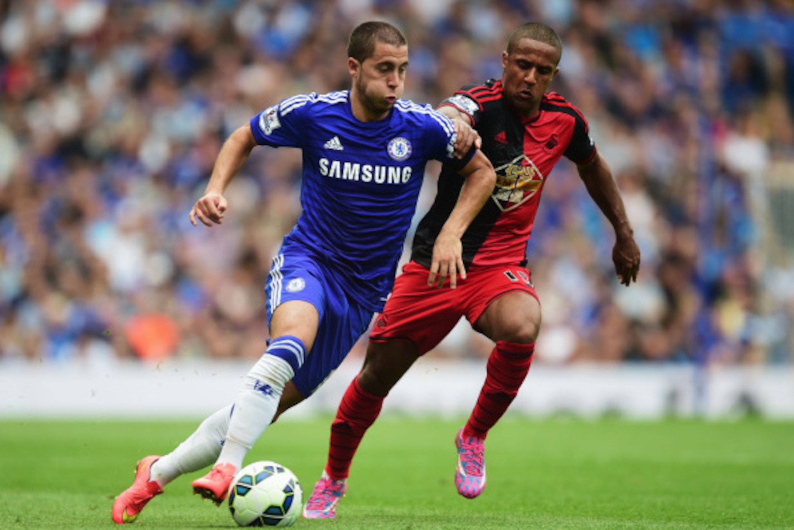 LONDON, ENGLAND - SEPTEMBER 13:  Eden Hazard of Chelsea takes on Wayne Routledge of Swansea City during the Barclays Premier League match between Chelsea and Swansea City at Stamford Bridge on September 13, 2014 in London, England.  (Photo by Jamie McDona