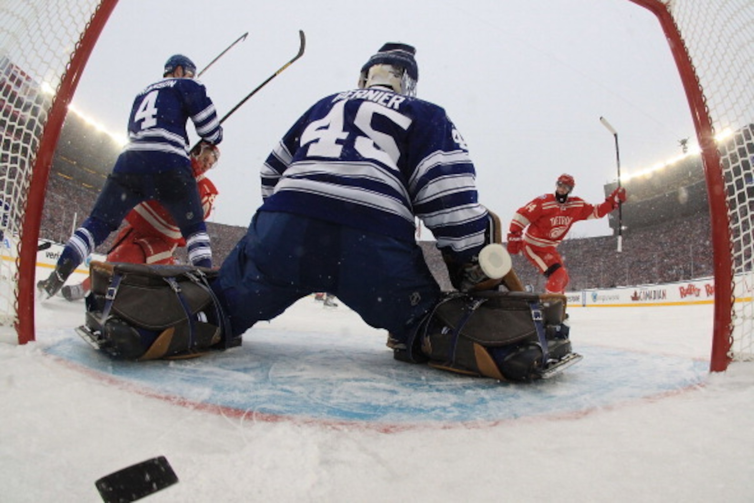 ANN ARBOR, MI - JANUARY 1:  Justin Abdelkader #8 of the Detroit Red Wings is checked to the ice by Cody Franson #4 of the Toronto Maple Leafs after he scored a third period goal on Jonathan Bernier #45 of the Leafs to tie the game 2-2 as teammate Todd Ber