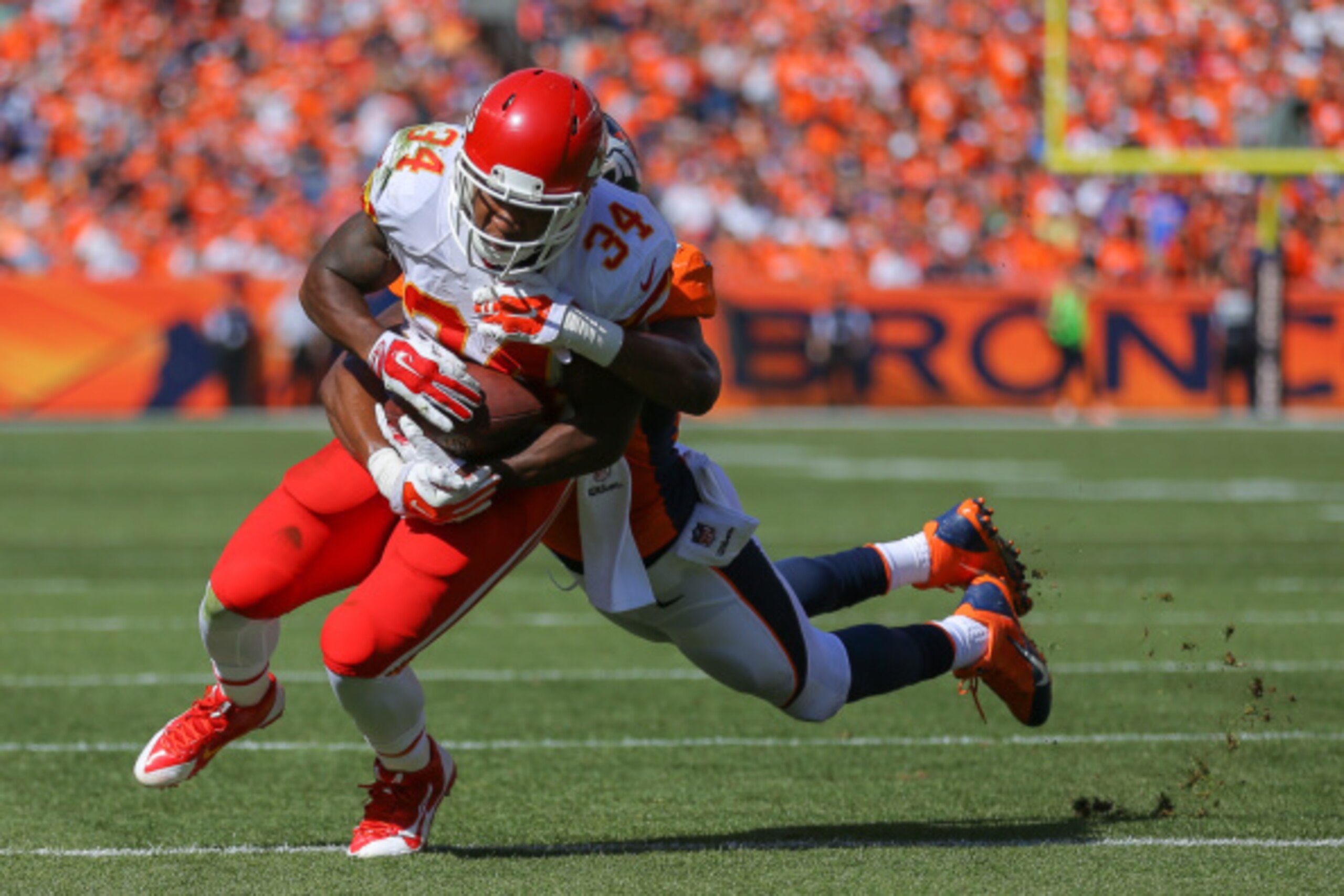 DENVER, CO - SEPTEMBER 14:  Running back Knile Davis #34 of the Kansas City Chiefs is tackled after a catch by outside linebacker Brandon Marshall #54 of the Denver Broncos in the second quarter of a game at Sports Authority Field at Mile High on Septembe