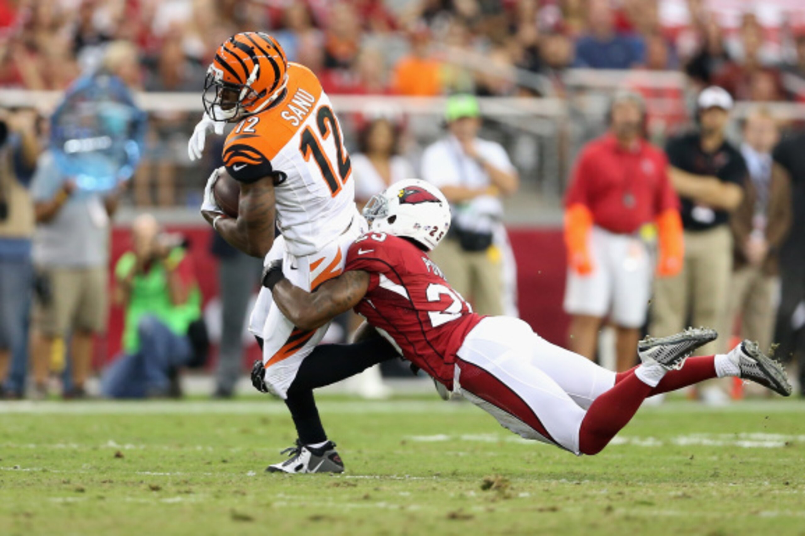 GLENDALE, AZ - AUGUST 24: Wide receiver Mohamed Sanu #12 of the Cincinnati Bengals makes a reception over cornerback Jerraud Powers #25 of the Arizona Cardinals during the second quarter of the preseason NFL game at the University of Phoenix Stadium on Au