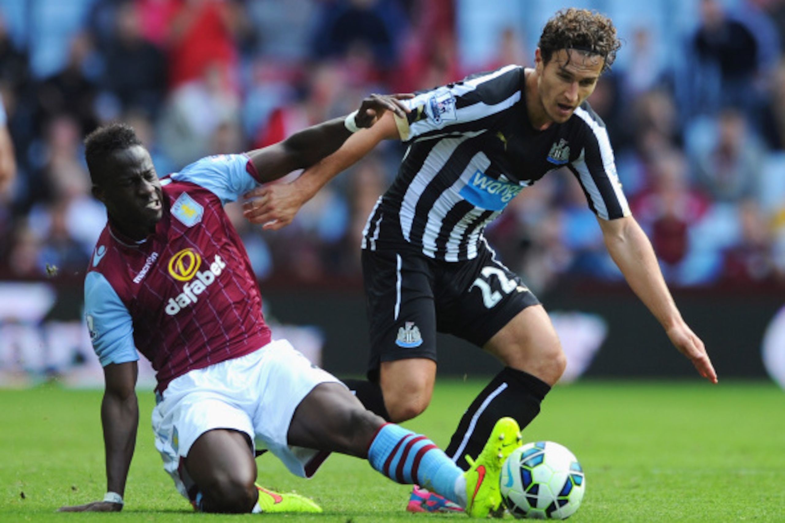 BIRMINGHAM, ENGLAND - AUGUST 23:  Daryl Janmaat of Newcastle United is tackled by Aly Cissokho of Aston Villa during the Barclays Premier League match between Aston Villa and Newcastle United at Villa Park on August 23, 2014 in Birmingham, England.  (Phot