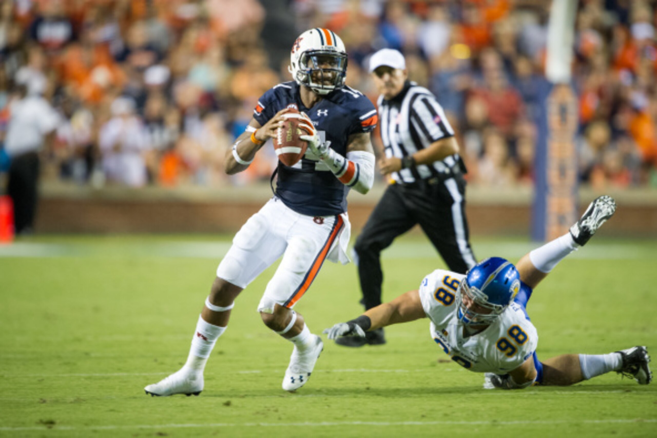 AUBURN, AL - SEPTEMBER 6: Quarterback Nick Marshall #14 of the Auburn Tigers looks downfield while avoiding a tackle by defensive tackle Tony Popovich #98 of the San Jose State Spartans on September 6, 2014 at Jordan-Hare Stadium in Auburn, Alabama. At ha