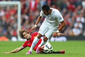 MANCHESTER, ENGLAND - SEPTEMBER 14:  Mauricio Isla of QPR is challenged by Daley Blind of Manchester United during the Barclays Premier League match between Manchester United and Queens Park Rangers at Old Trafford on September 14, 2014 in Manchester, Eng