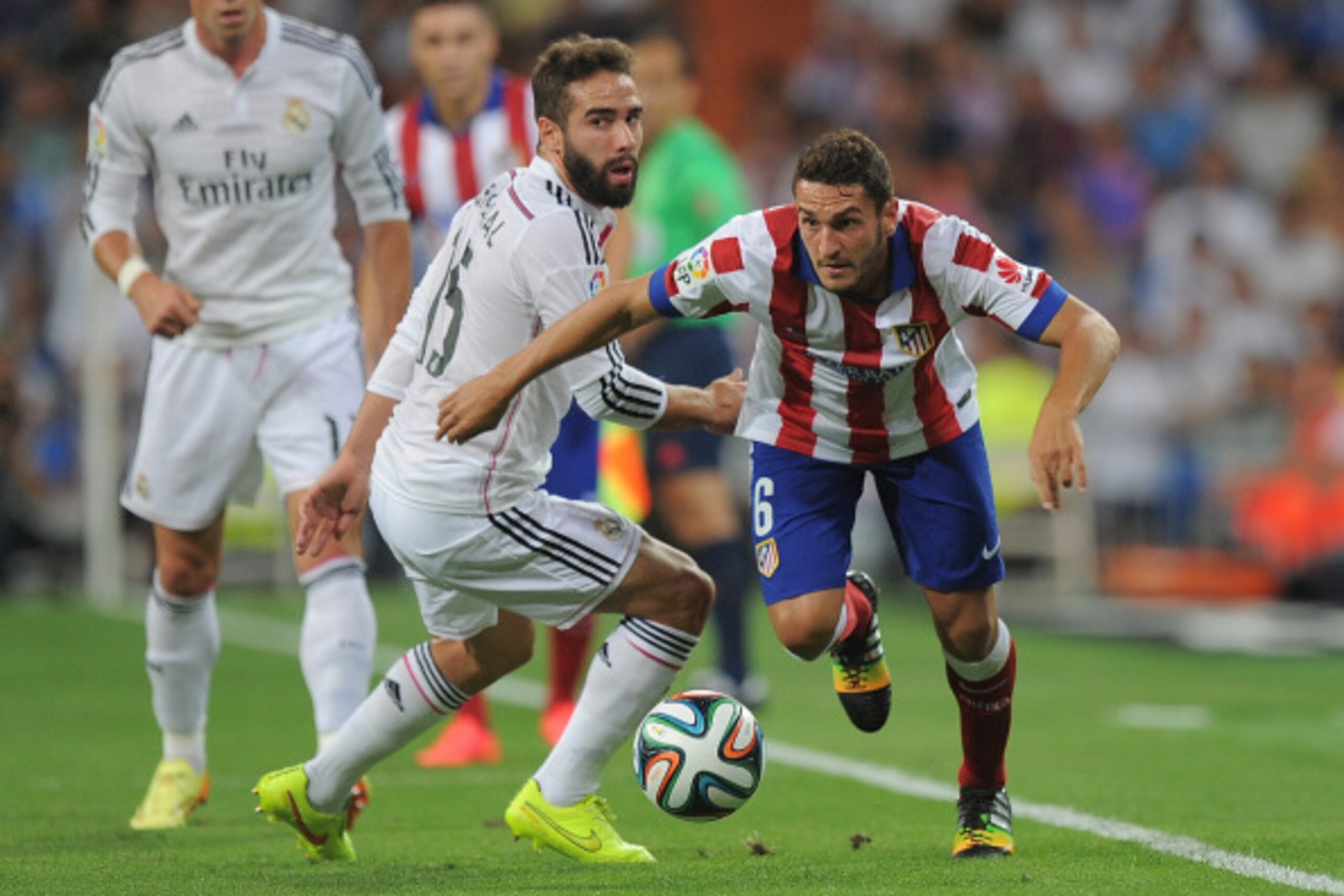 MADRID, SPAIN - AUGUST 19:  Koke of Club Atletico de Madrid gets the better of Daniel Carvajal of Real Madrid during the Supercopa first leg match between Real Madrid and Club Atletico de Madrid     at Estadio Santiago Bernabeu on August 19, 2014 in Madri