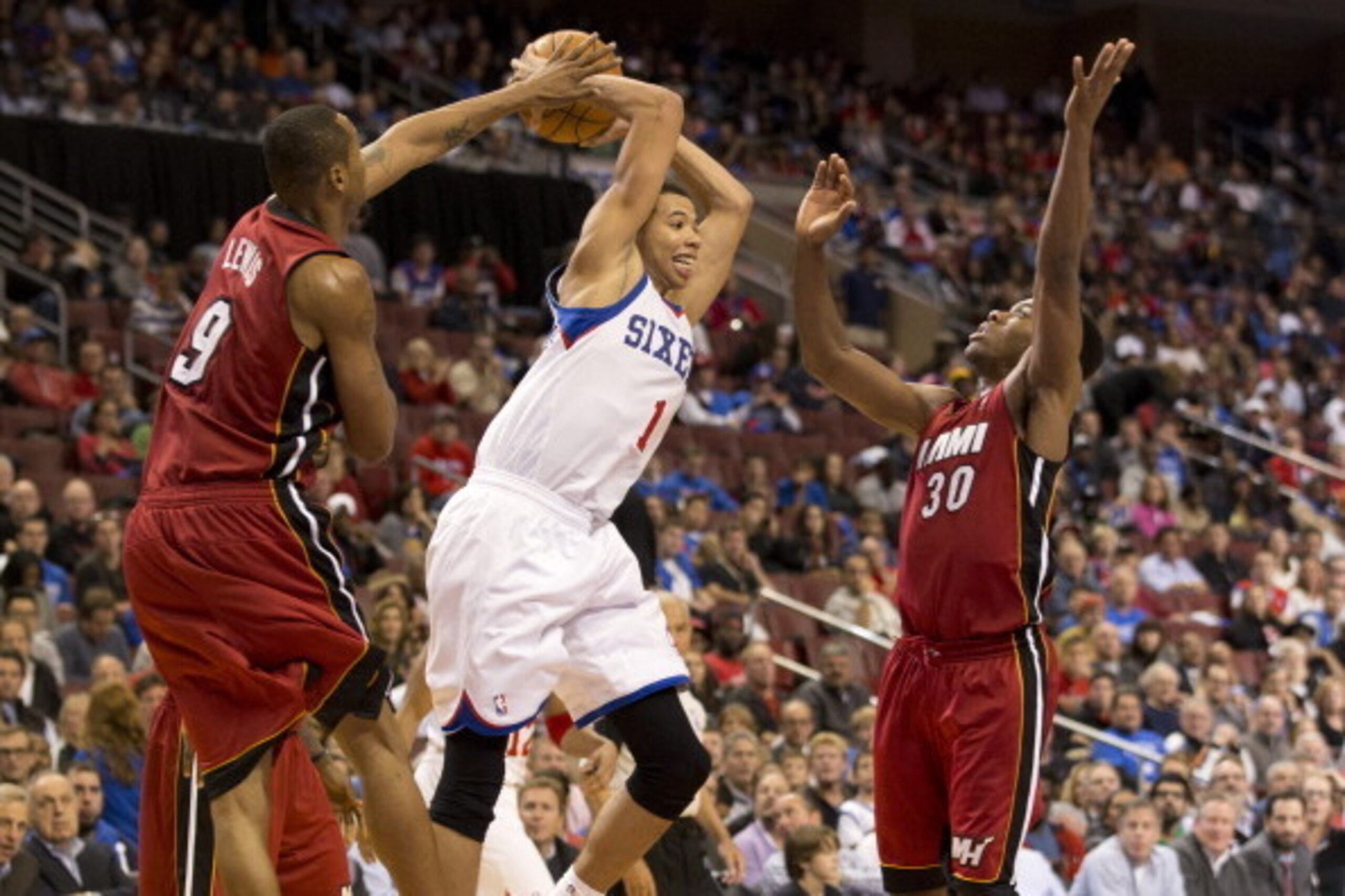 PHILADELPHIA, PA - OCTOBER 30: Guard Michael Carter-Williams #1 of the Philadelphia 76ers passes the ball against forward Rashard Lewis #9 and guard Norris Cole #30 of the Miami Heat on October 30, 2013 at the Wells Fargo Center in Philadelphia, Pennsylva