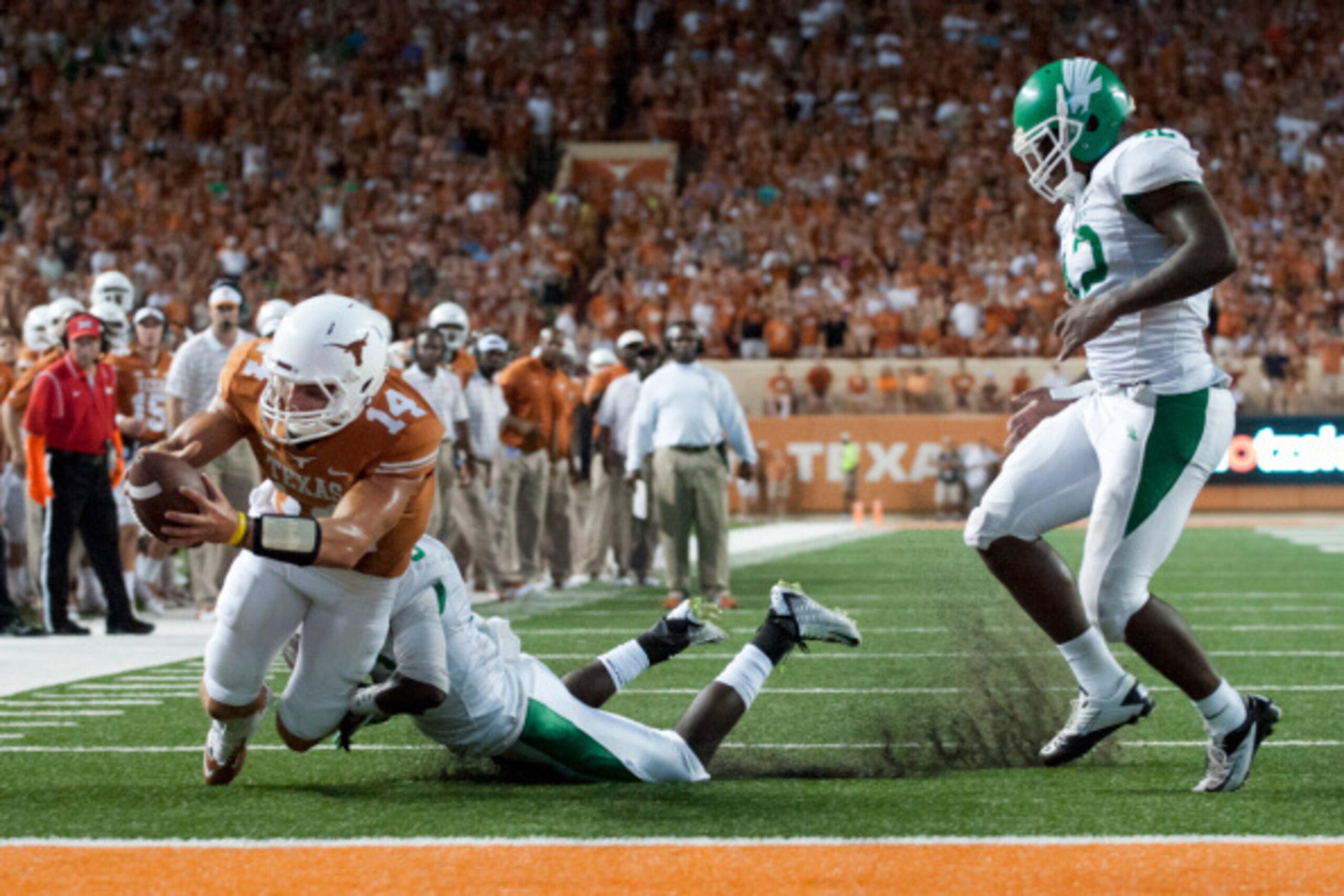 AUSTIN, TX - AUGUST 30:  David Ash #14 of the Texas Longhorns rushes for a 1 yard touchdown against the North Texas Mean Green during the second quarter on August 30, 2014 at Darrell K Royal-Texas Memorial Stadium in Austin, Texas.  (Photo by Cooper Neill