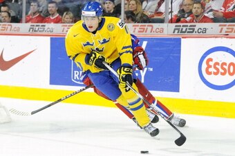 CALGARY, CANADA - JANUARY 5:  Victor Rask #18 of Team Sweden skates with the puck while being chased by Nikita Gusev #8 of Team Russia during the 2012 World Junior Hockey Championship Gold Medal game at the Scotiabank Saddledome on January 5, 2012 in Calg