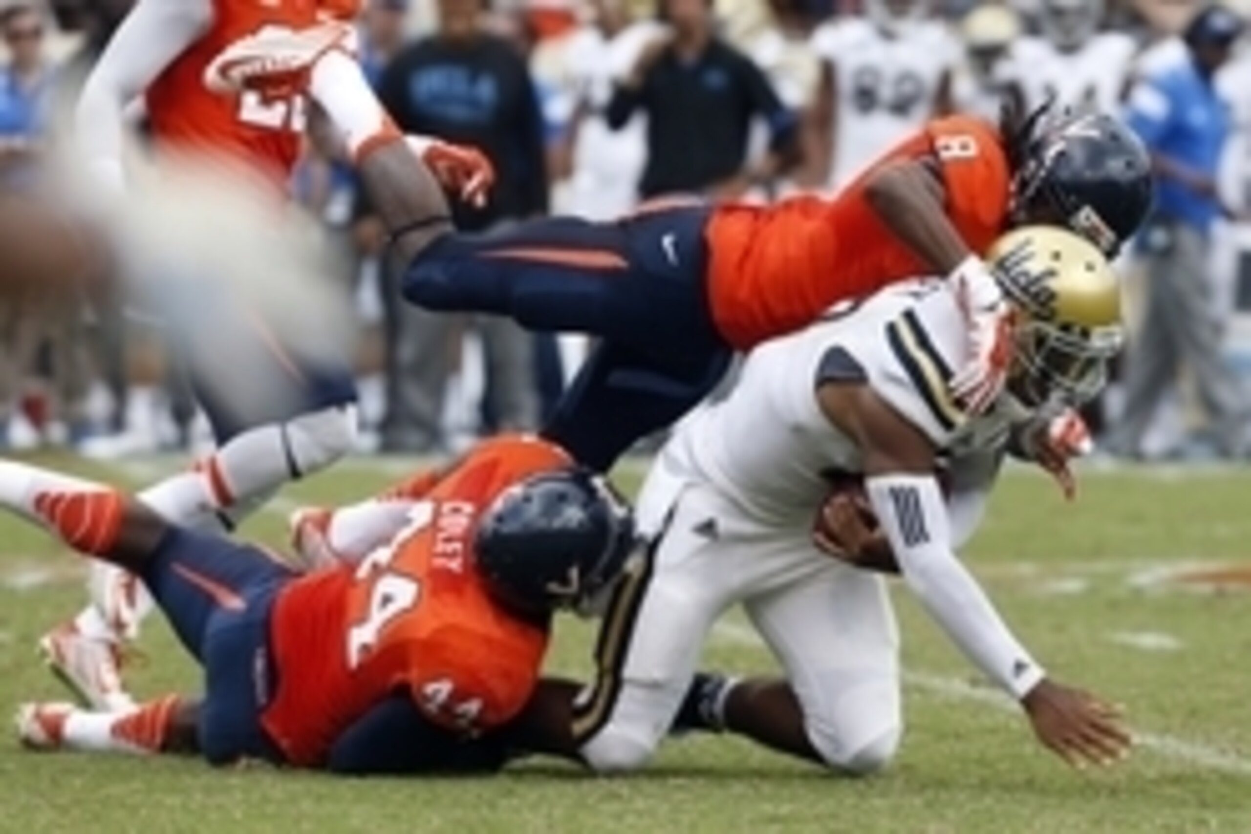 Aug 30, 2014; Charlottesville, VA, USA; UCLA Bruins quarterback Brett Hundley (17) runs with the ball as Virginia Cavaliers safety Anthony Harris (8) and Cavaliers linebacker Henry Coley (44) make the tackle the tackle in the third quarter at Scott Stadiu