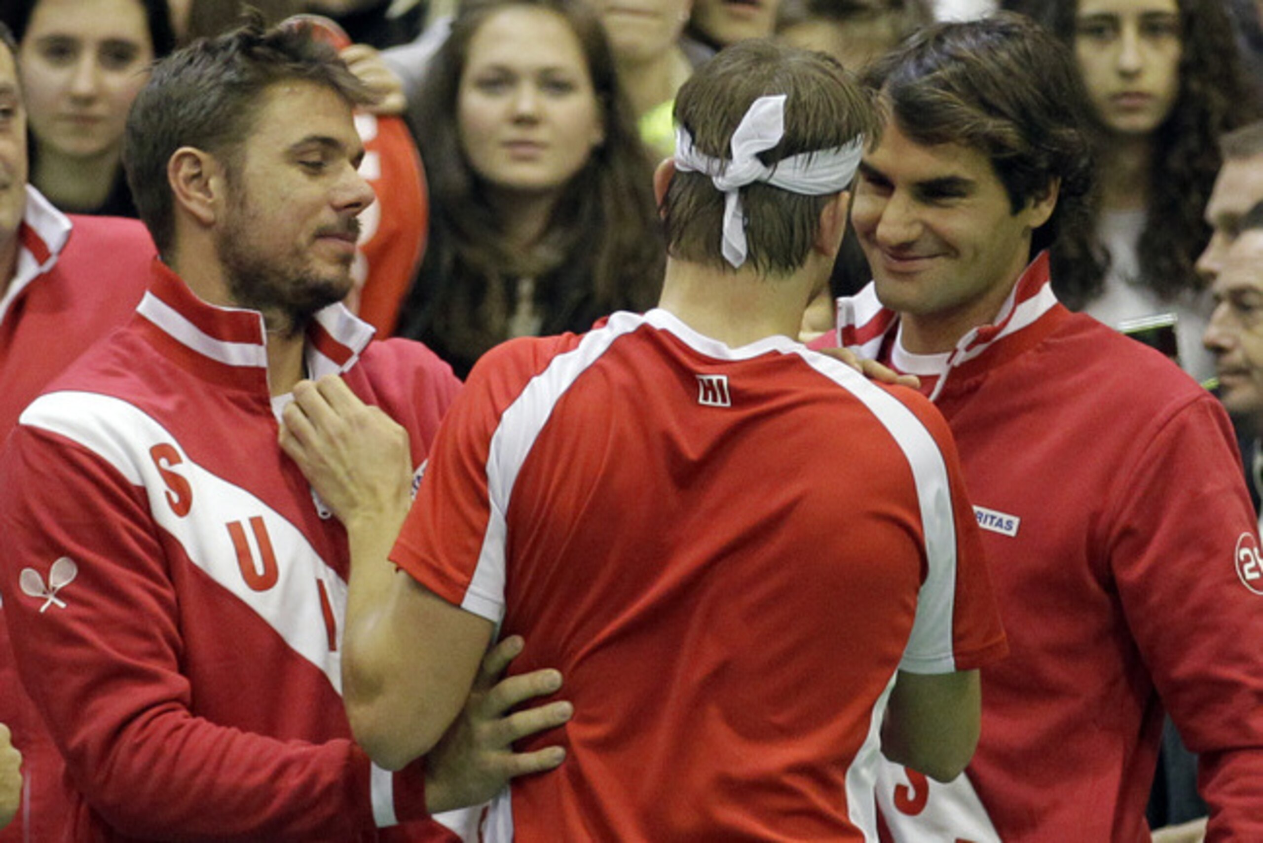 Stan Wawrinka and Roger Federer congratulate a Davis Cup teammate.