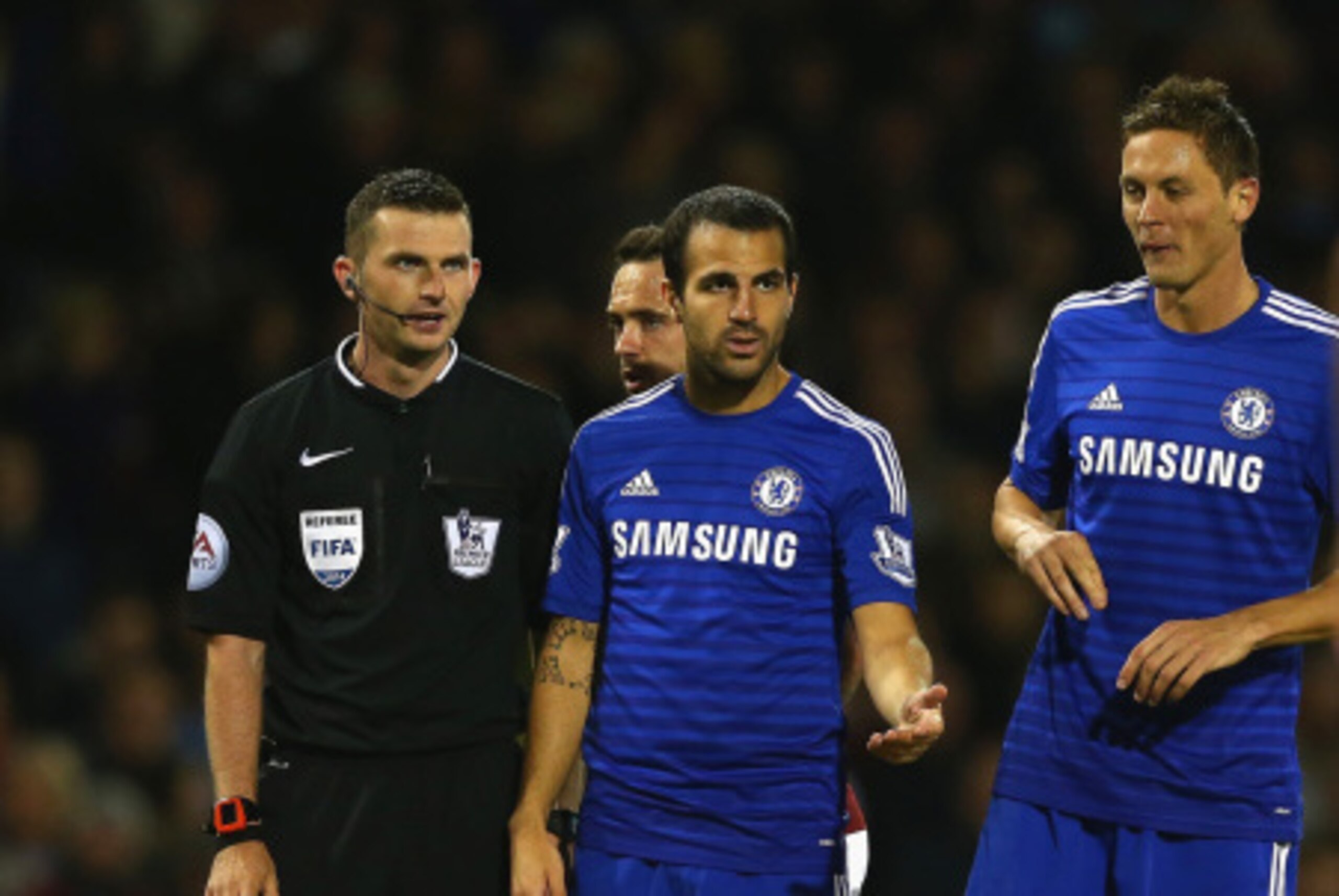 BURNLEY, ENGLAND - AUGUST 18:   Referee Michael Oliver speaks to Cesc Fabregas and Nemanja Matic of Chelsea during the Barclays Premier League match between Burnley and Chelsea at Turf Moor on August 18, 2014 in Burnley, England.  (Photo by Clive Brunskil