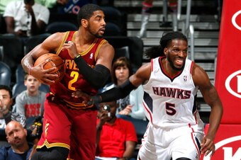 ATLANTA, GA - APRIL 04:  Kyrie Irving #2 of the Cleveland Cavaliers grabs a rebound against DeMarre Carroll #5 of the Atlanta Hawks at Philips Arena on April 4, 2014 in Atlanta, Georgia.  NOTE TO USER: User expressly acknowledges and agrees that, by downl