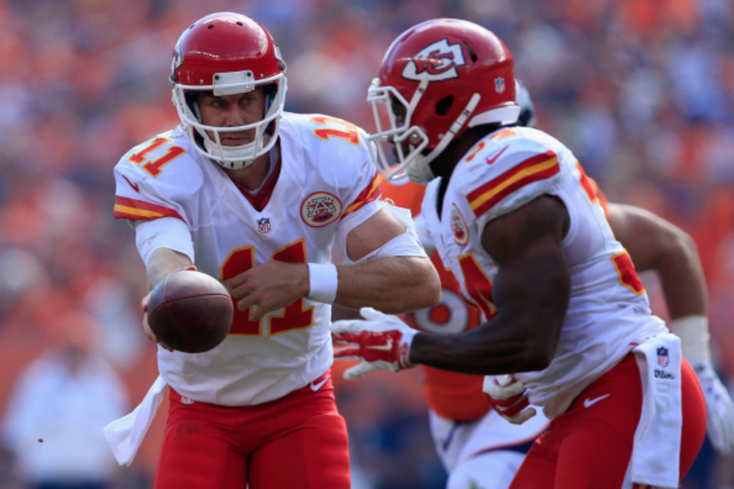 DENVER, CO - SEPTEMBER 14:  Quarterback Alex Smith #11 of the Kansas City Chiefs hands the ball off to running back Knile Davis #34 of the Kansas City Chiefs against the Denver Broncos at Sports Authority Field at Mile High on September 14, 2014 in Denver