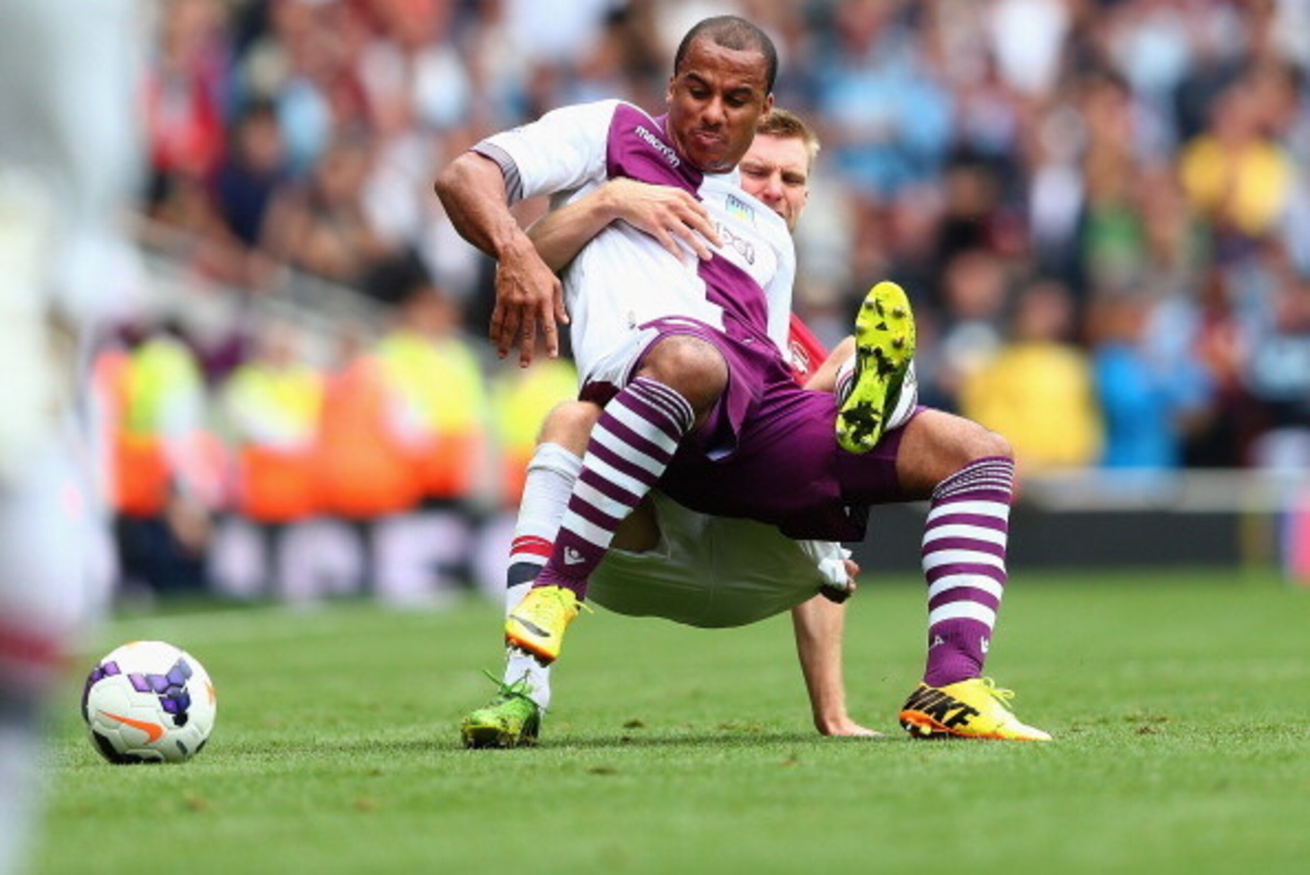 LONDON, ENGLAND - AUGUST 17: Gabriel Agbonlahor of Aston Villa is challenged by Per Mertesacker of Arsenal during the Barclays Premier League match between Arsenal and Aston Villa at Emirates Stadium on August 17, 2013 in London, England. (Photo by Clive 