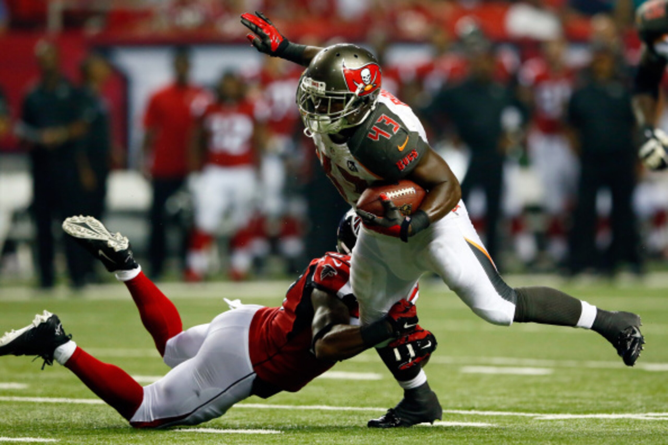 ATLANTA, GA - SEPTEMBER 18: Running back Bobby Rainey #43 of the Tampa Bay Buccaneers breaks a tackle by cornerback Robert McClain #27 of the Atlanta Falcons during a game at the Georgia Dome on September 18, 2014 in Atlanta, Georgia. (Photo by Kevin C. ATLANTA, GA - SEPTEMBER 18: Running back Bobby Rainey #43 of the Tampa Bay Buccaneers breaks a tackle by cornerback Robert McClain #27 of the Atlanta Falcons during a game at the Georgia Dome on September 18, 2014 in Atlanta, Georgia. (Photo by Kevin C.