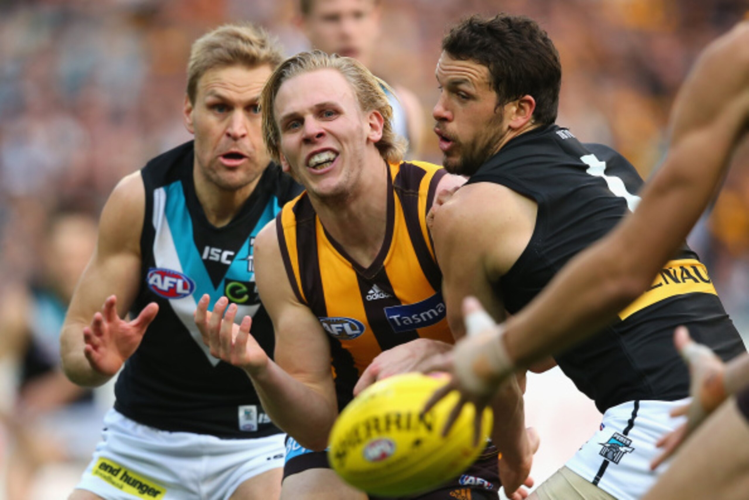 MELBOURNE, AUSTRALIA - SEPTEMBER 20:  Will Langford of the Hawks handballs whilst being tackled by Kane Cornes and Travis Boak of the Power during the AFL 2nd Preliminary Final match between the Hawthorn Hawks and the Port Adelaide Power at Melbourne Cric