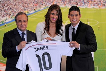 MADRID, SPAIN - JULY 22:  James Rodriguez holds his new Real shirt beside club president Florentino Perez and his wife Daniela Ospina during his unveiling as a new Real Madrid player at the Santaigo Bernabeu stadium on July 22, 2014 in Madrid, Spain. Real