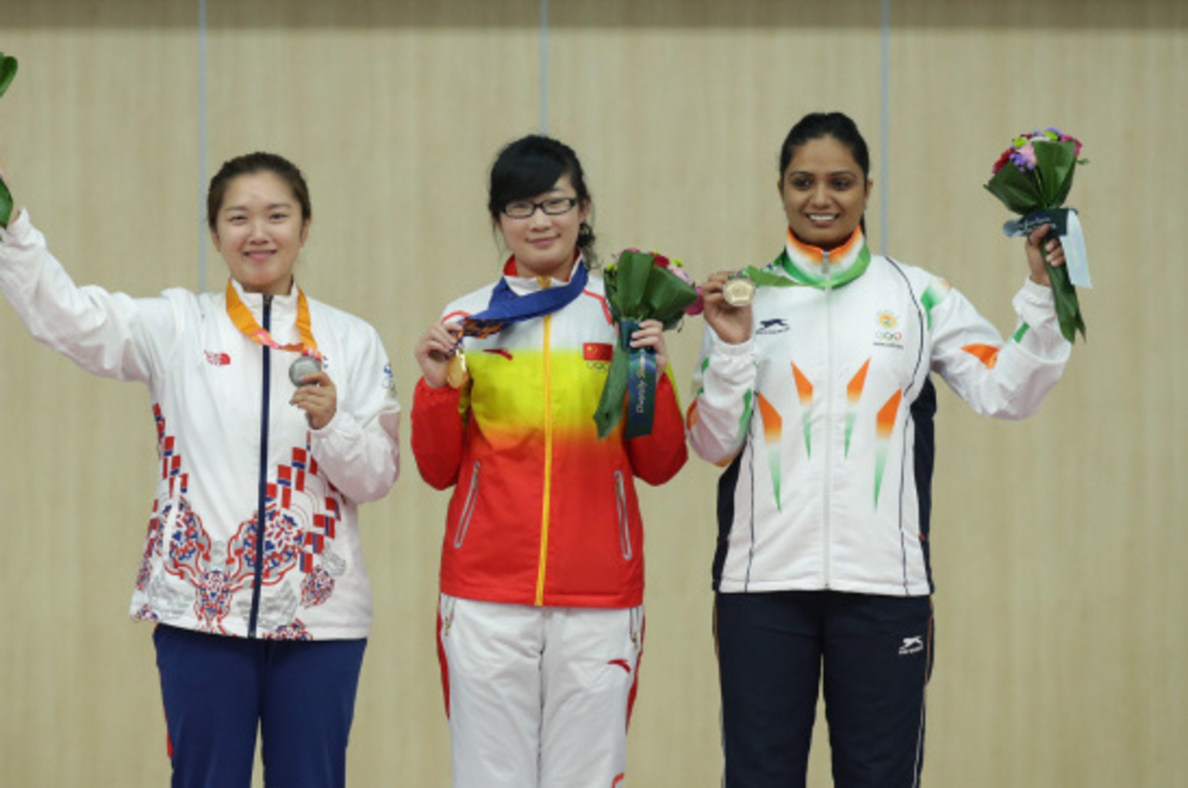 INCHEON, SOUTH KOREA - SEPTEMBER 20: Gold Medalist Mengyuan Zhang of China (C), Silver Medalist Jung Jee-Hae of South Korea (L), and Bronze Medalist Shweta Chaudhry of India (R) celebrate on the podium after winning their medals in the 10m Air Pistol Wome INCHEON, SOUTH KOREA - SEPTEMBER 20: Gold Medalist Mengyuan Zhang of China (C), Silver Medalist Jung Jee-Hae of South Korea (L), and Bronze Medalist Shweta Chaudhry of India (R) celebrate on the podium after winning their medals in the 10m Air Pistol Wome