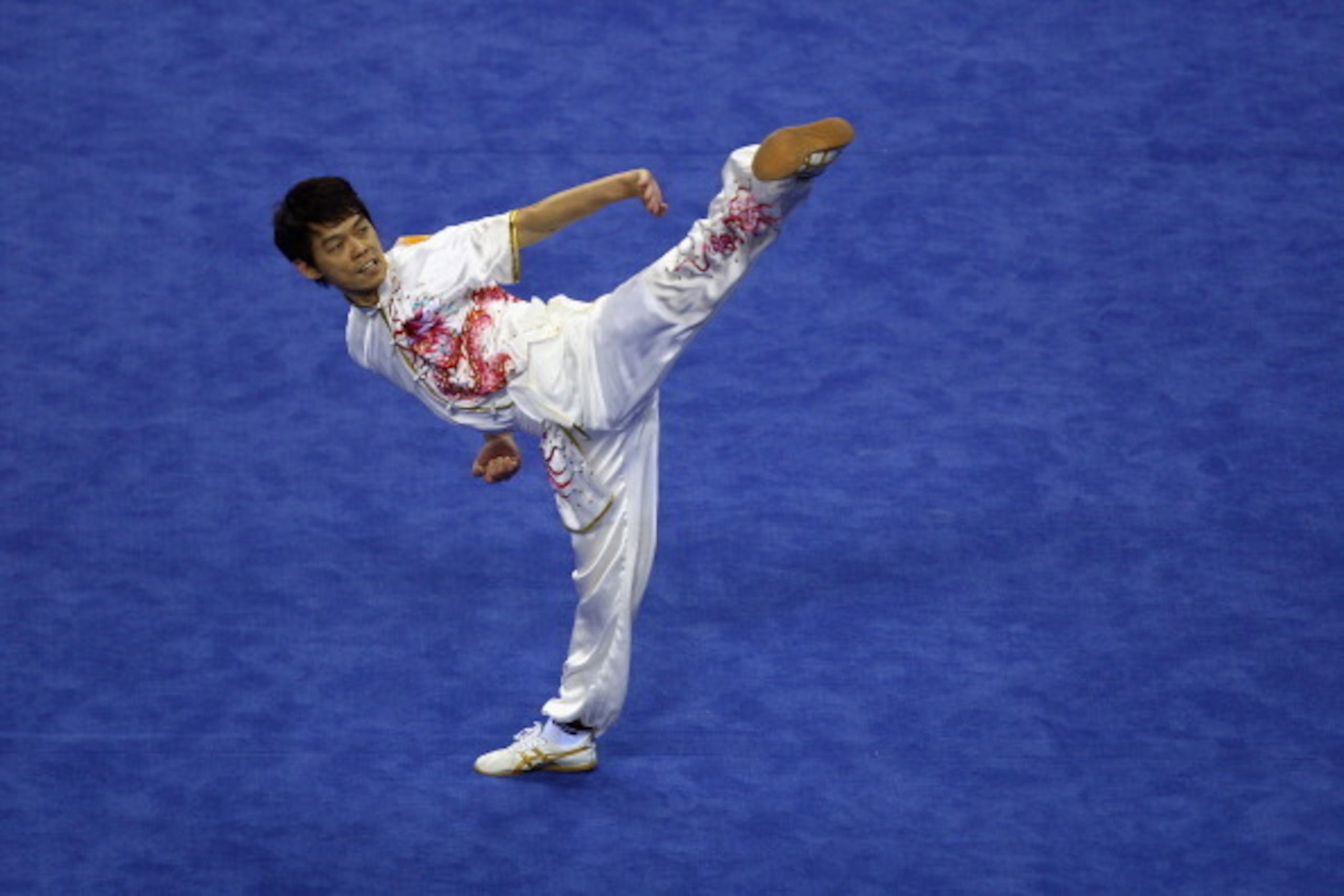 GUANGZHOU, CHINA - NOVEMBER 13:  Eng Chong Ang of Malaysia competes in the Men's Changquan discipline of Wushu at the Nansha Gymnasium during day one of the 16th Asian Games Guangzhou 2010 on November 13, 2010 in Guangzhou, China.  (Photo by Richard Heath