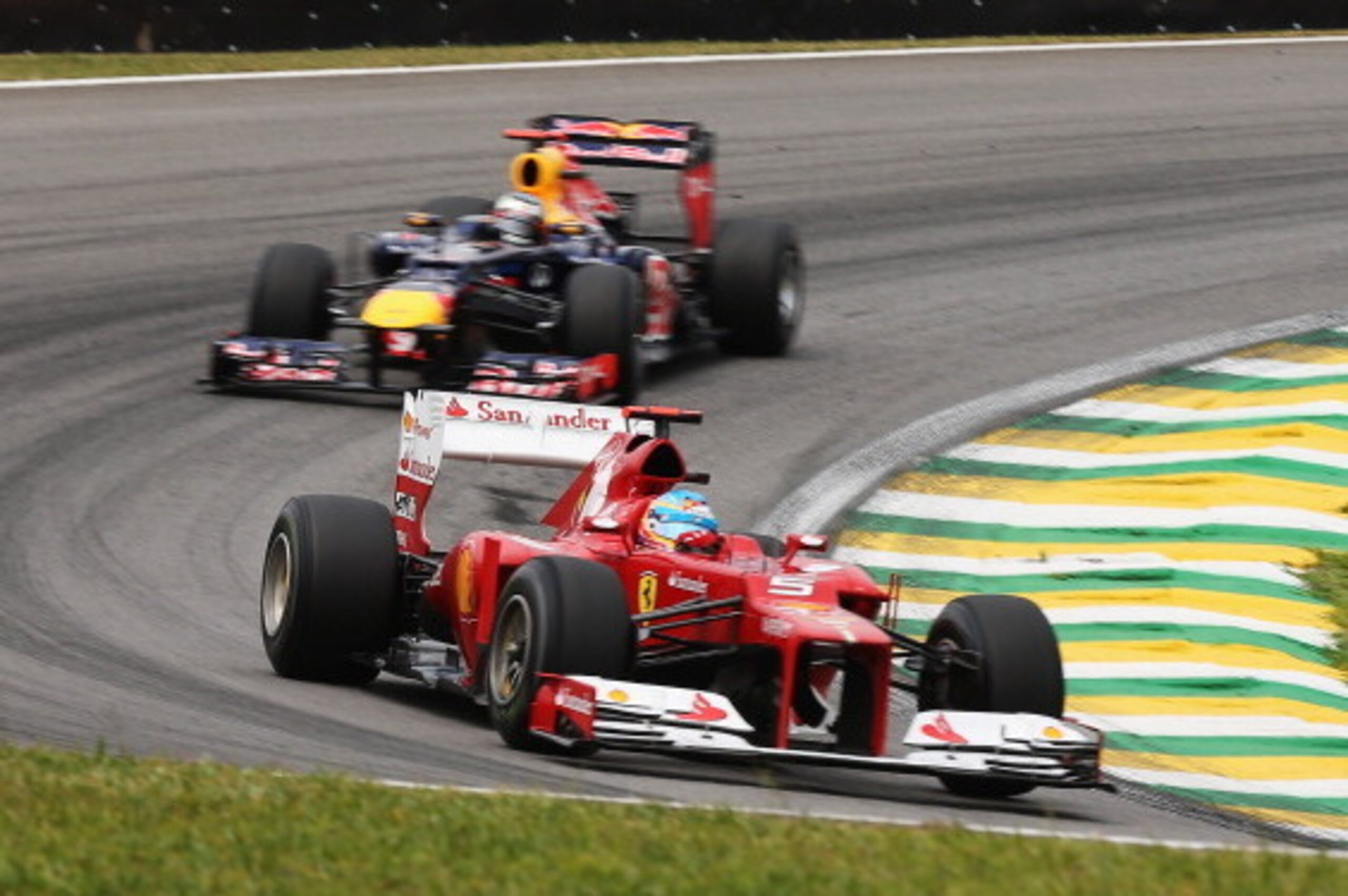 SAO PAULO, BRAZIL - NOVEMBER 24:  Fernando Alonso of Spain and Ferrari drives ahead of Sebastian Vettel of Germany and Red Bull Racing during the final practice session prior to qualifying for the Brazilian Formula One Grand Prix at the Autodromo Jose Car