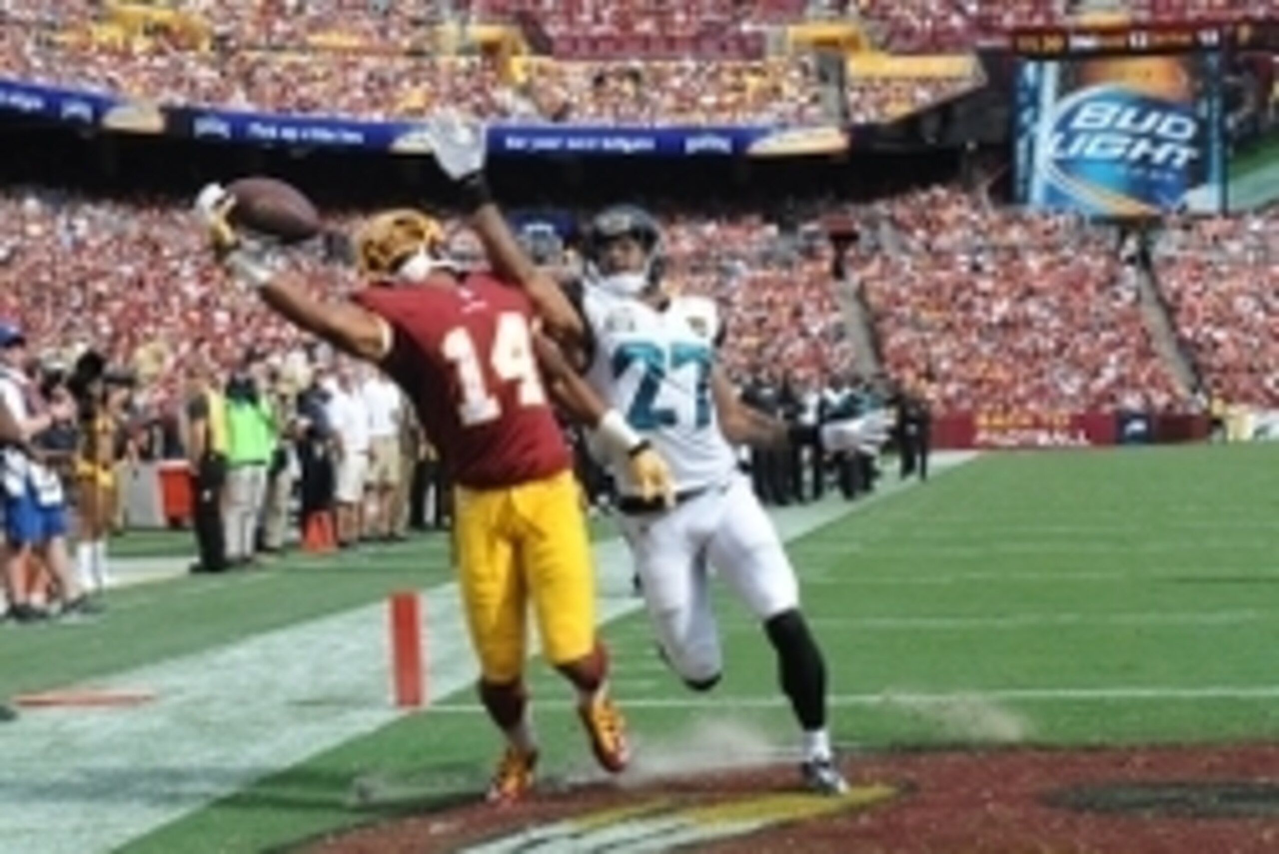 Sep 14, 2014; Landover, MD, USA; Washington Redskins wide receiver Ryan Grant (14) is unable to control the ball as Jacksonville Jaguars cornerback Dwayne Gratz (27) defends during the second half at FedEx Field. Mandatory Credit: Brad Mills-USA TODAY Spo