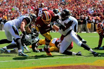LANDOVER, MD - SEPTEMBER 14:  Running back Alfred Morris #46 of the Washington Redskins scores a touchdown past linebacker Dekoda Watson #57 of the Jacksonville Jaguars at FedExField on September 14, 2014 in Landover, Maryland.  (Photo by Rob Carr/Getty I