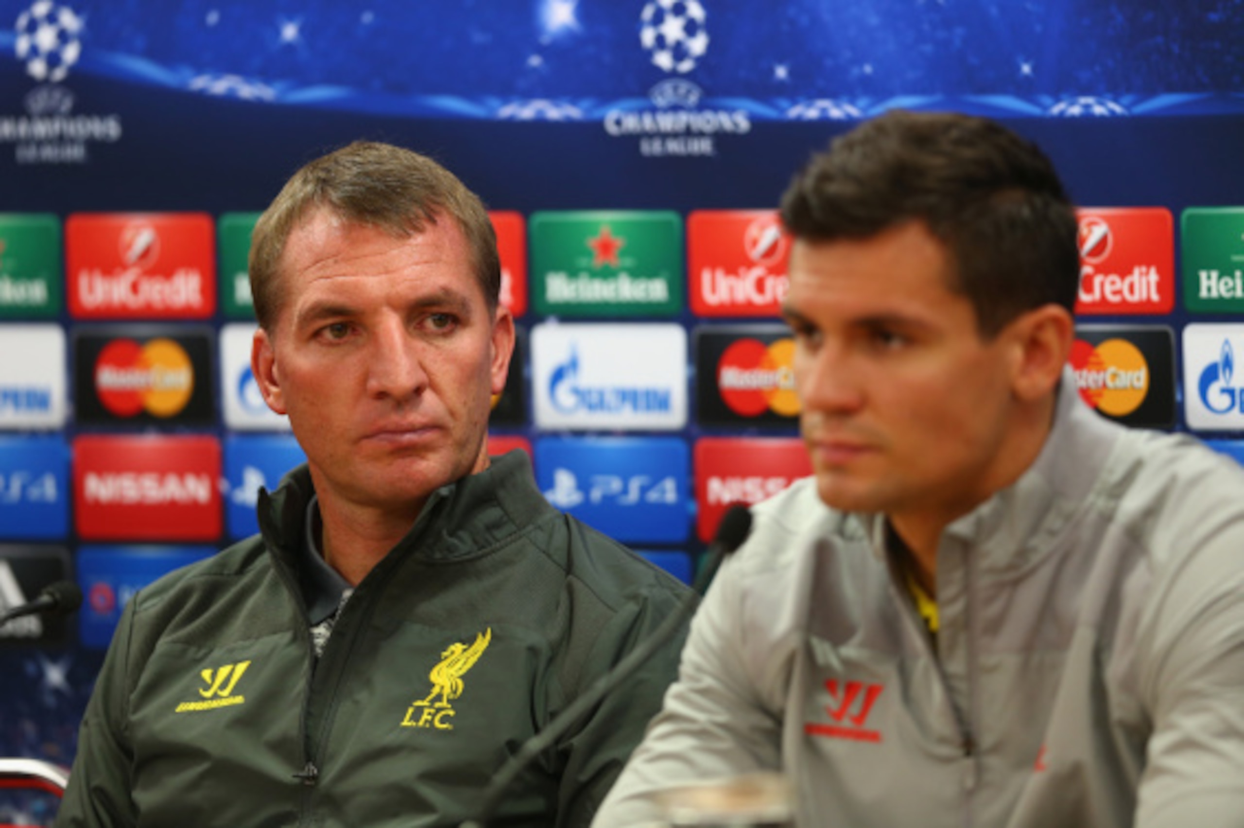 LIVERPOOL, ENGLAND - SEPTEMBER 15:  Liverpool manager Brendan Rodgers deep in thought whilst sitting next to his defender Dejan Lovren during a press conference ahead of their UEFA Champions League group B match against PFC Ludogorets on September 15, 201