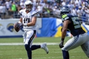 Sep 14, 2014; San Diego, CA, USA; San Diego Chargers quarterback Philip Rivers (17) scrambles away from Seattle Seahawks outside linebacker Malcolm Smith (53) during first half action at Qualcomm Stadium. Mandatory Credit: Robert Hanashiro-USA TODAY Sport