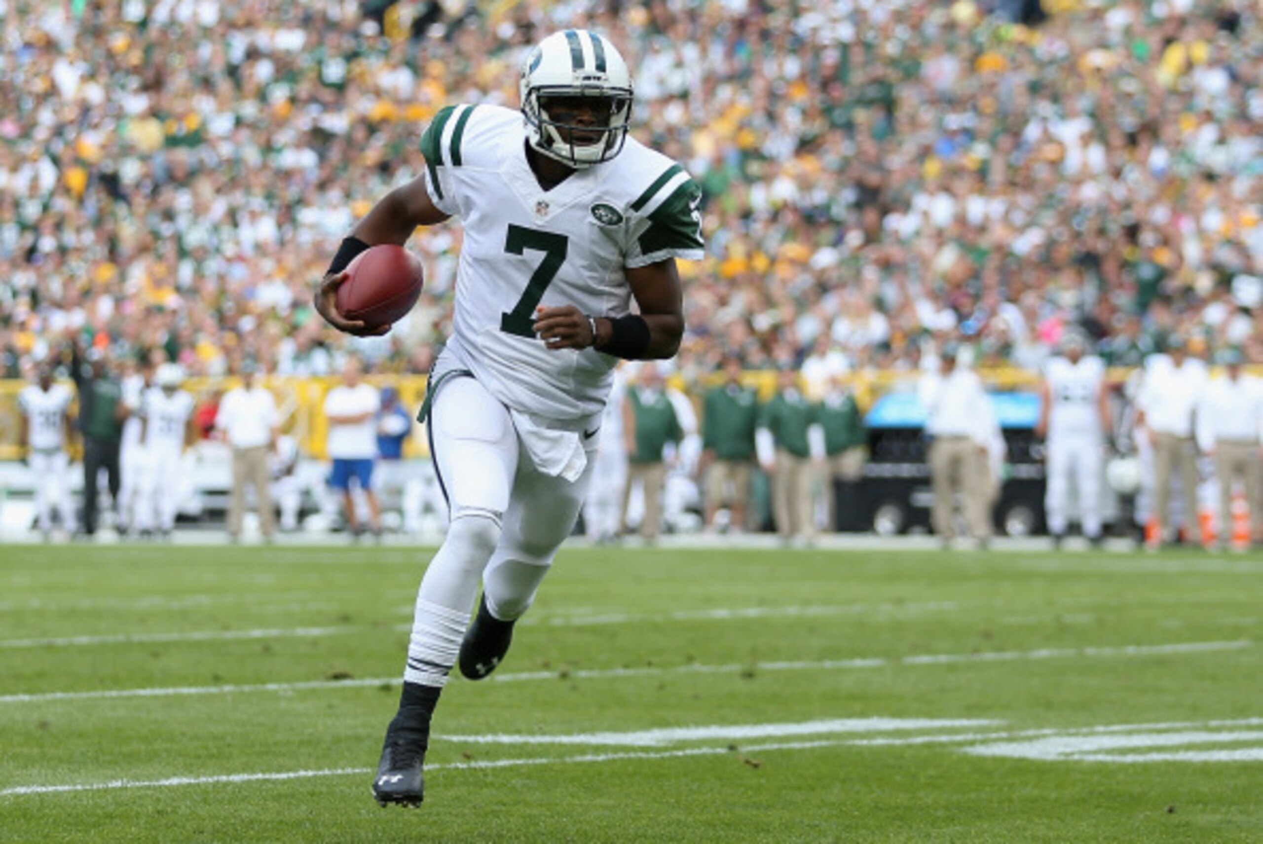 GREEN BAY, WI - SEPTEMBER 14:  Quarterback Geno Smith #7 of the New York Jets scores a rushing touchdown against the Green Bay Packers in the first quarter during the NFL game at Lambeau Field on September 14, 2014 in Green Bay, Wisconsin.  The Packers de