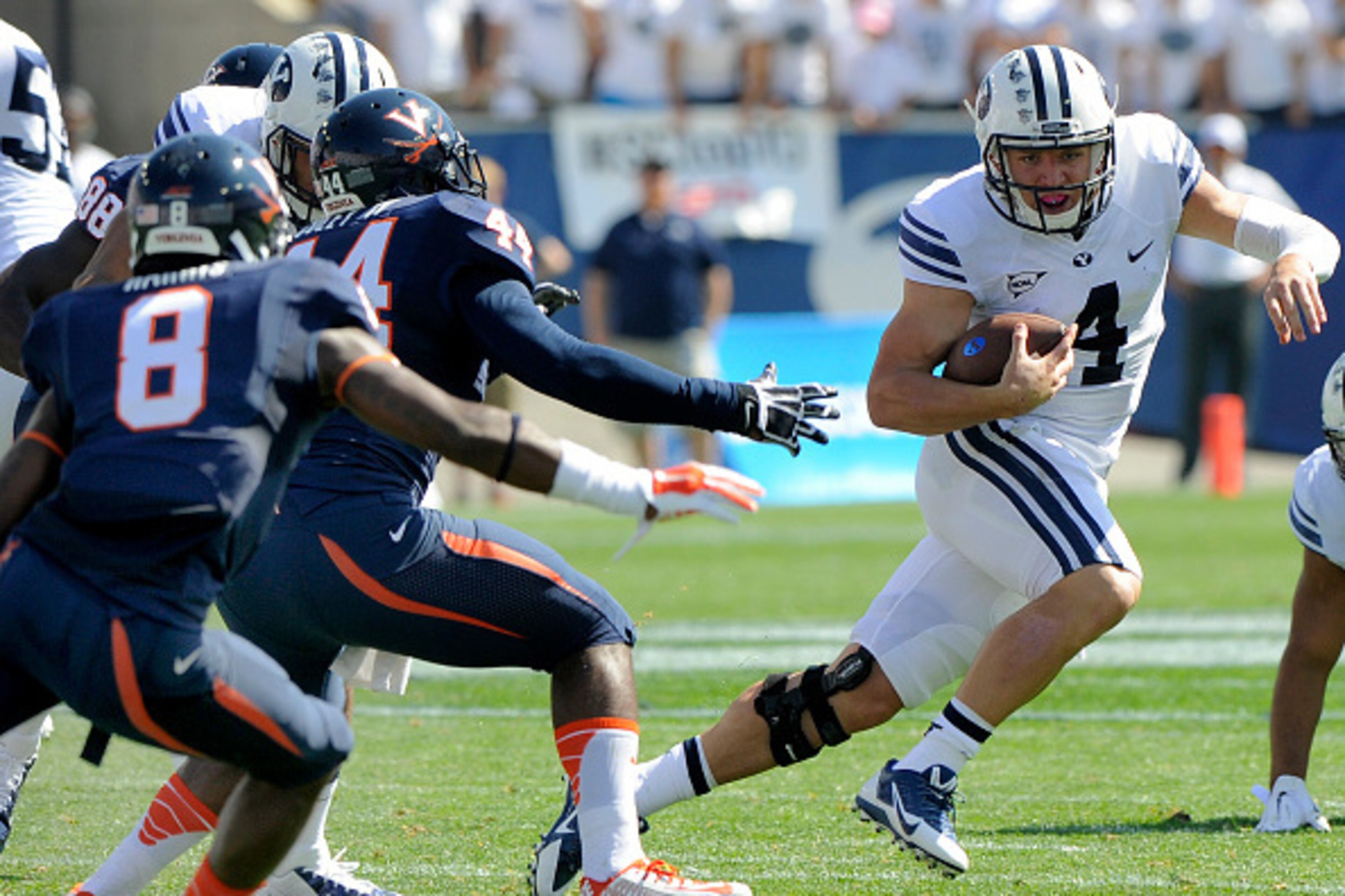 PROVO, UT - SEPTEMBER 20: Quarterback Taysom Hill #4 of the Brigham Young Cougars avoids tacklers from the Virginia Cavaliers during the first quarter of their game at LaVell Edwards Stadium on September 20, 2014 in Provo, Utah. (Photo by Gene Sweeney Jr/ PROVO, UT - SEPTEMBER 20: Quarterback Taysom Hill #4 of the Brigham Young Cougars avoids tacklers from the Virginia Cavaliers during the first quarter of their game at LaVell Edwards Stadium on September 20, 2014 in Provo, Utah. (Photo by Gene Sweeney Jr/