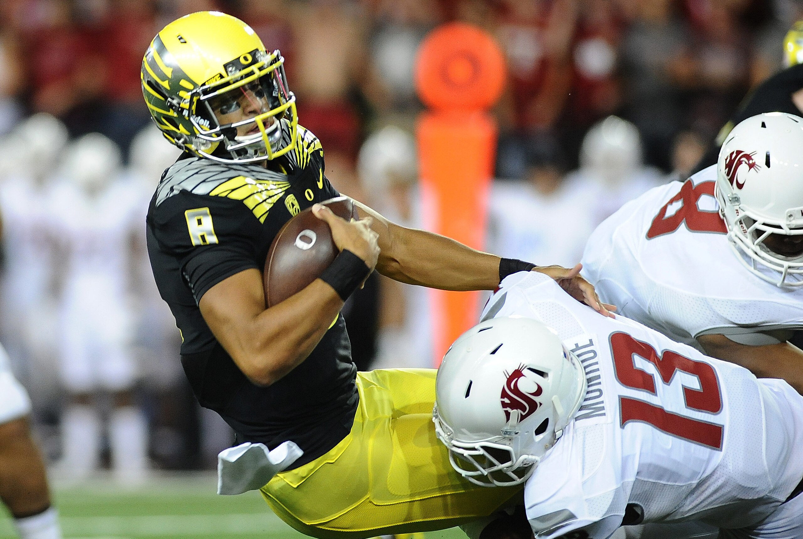 Sep 20, 2014; Pullman, WA, USA; Oregon Ducks quarterback Marcus Mariota (8) is sacked by Washington State Cougars linebacker Darryl Monroe (13) during the first half at Martin Stadium. Mandatory Credit: James Snook-USA TODAY Sports Sep 20, 2014; Pullman, WA, USA; Oregon Ducks quarterback Marcus Mariota (8) is sacked by Washington State Cougars linebacker Darryl Monroe (13) during the first half at Martin Stadium. Mandatory Credit: James Snook-USA TODAY Sports