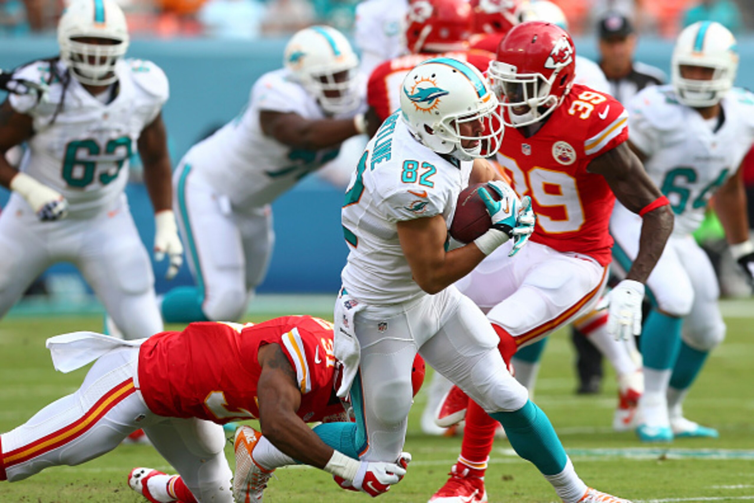 MIAMI GARDENS, FL - SEPTEMBER 21:  Wide receiver Brian Hartline #82 of the Miami Dolphins picks up yardage before being tackled by cornerback Marcus Cooper #31 of the Kansas City Chiefs at Sun Life Stadium on September 21, 2014 in Miami Gardens, Florida. 