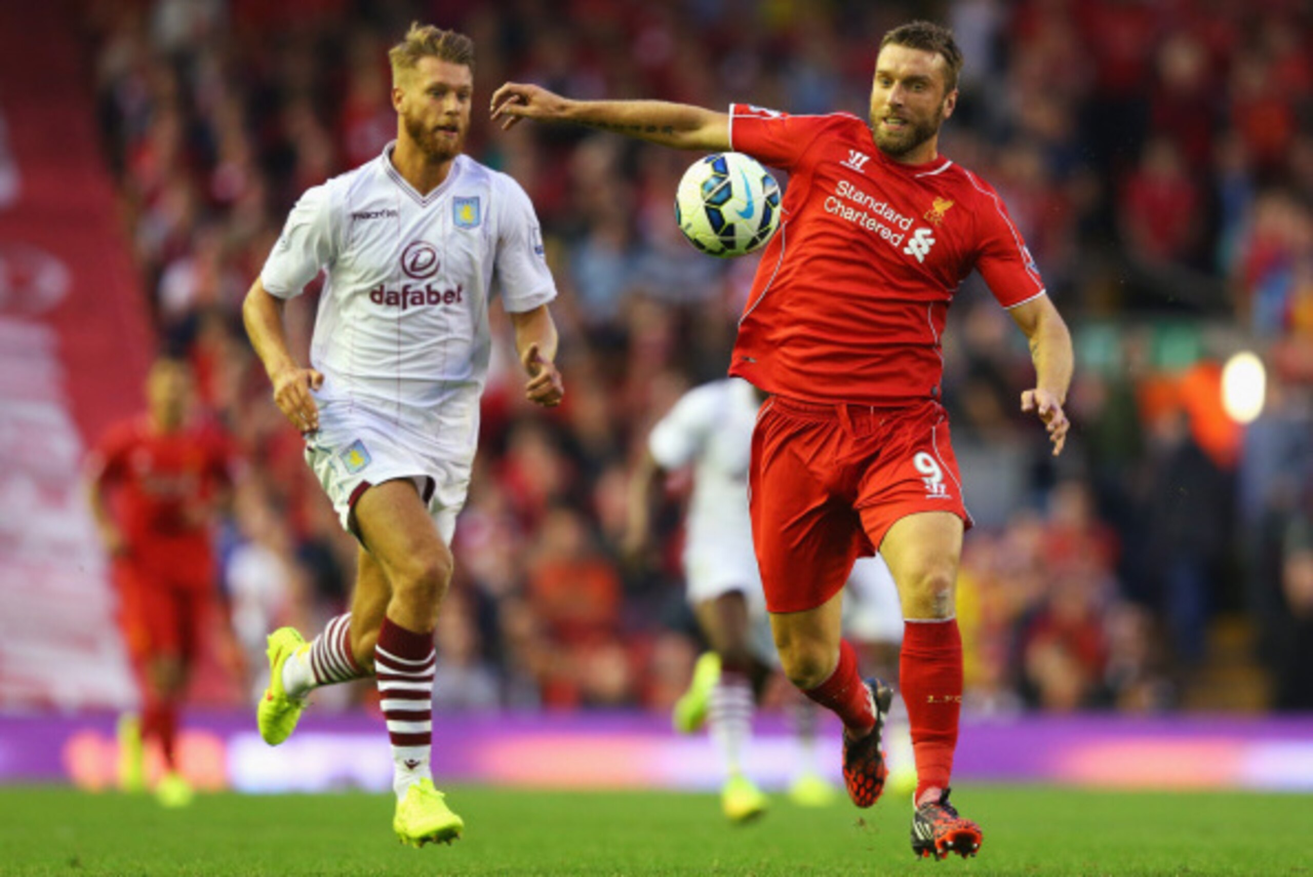 LIVERPOOL, ENGLAND - SEPTEMBER 13:  Rickie Lambert of Liverpool takes the ball away from Nathan Baker of Aston Villa during the Barclays Premier League match between Liverpool and Aston Villa at Anfield on September 13, 2014 in Liverpool, England.  (Photo