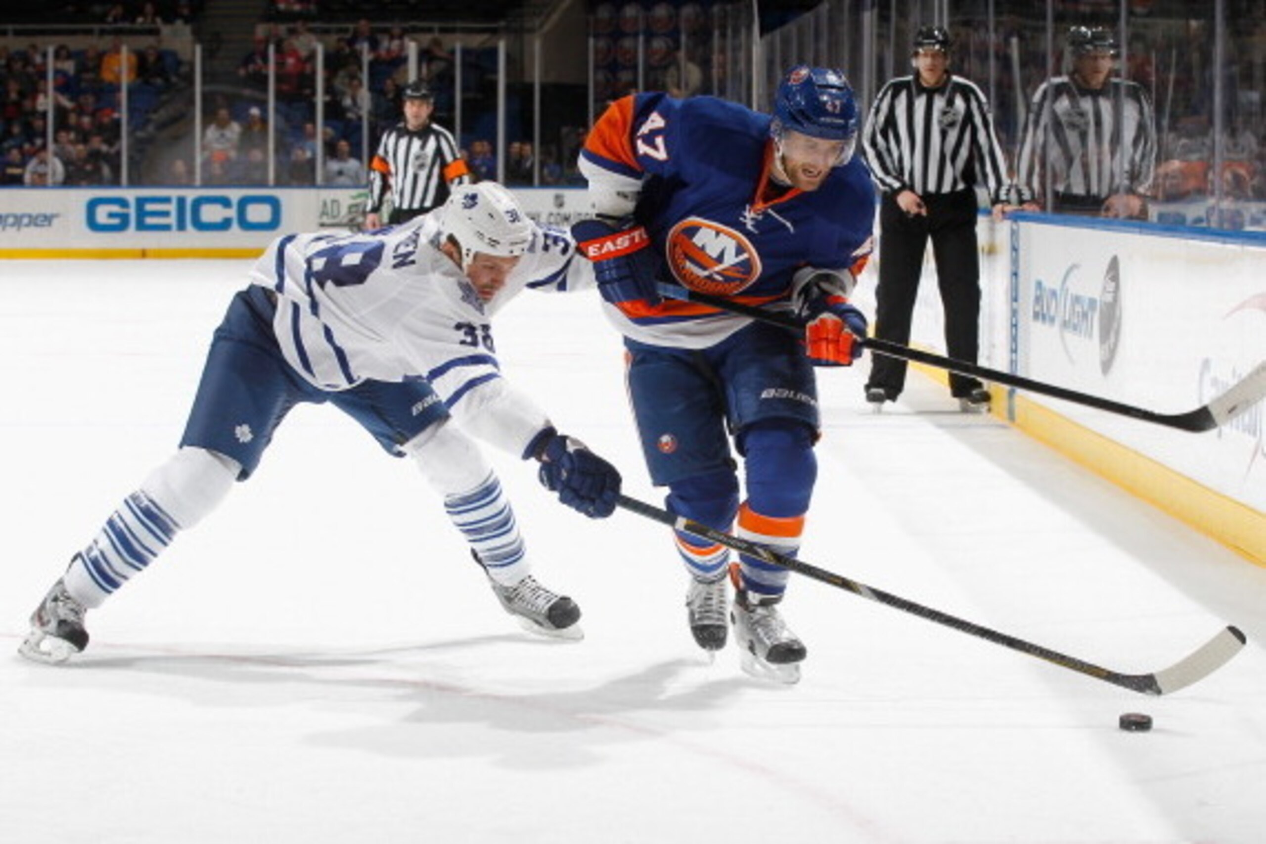 UNIONDALE, NY - FEBRUARY 28: Andrew MacDonald #47 of the New York Islanders is tripped up by Frazer McLaren #38 of the Toronto Maple Leafs at Nassau Veterans Memorial Coliseum on February 28, 2013 in Uniondale, New York.  (Photo by Mike Stobe/NHLI via Get