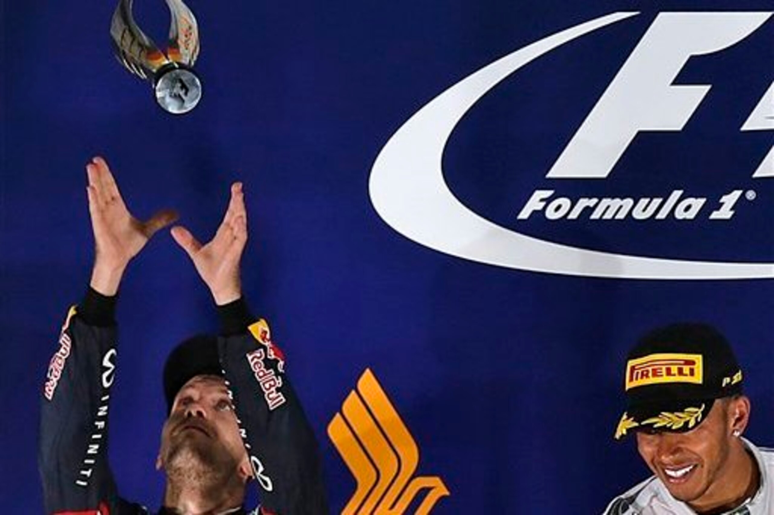 Vettel tosses his trophy on the Singapore podium.
