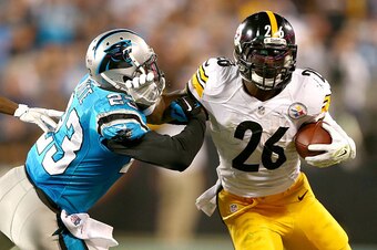 CHARLOTTE, NC - SEPTEMBER 21:  Melvin White #23 of the Carolina Panthers tries to stop Le'Veon Bell #26 of the Pittsburgh Steelers in the first half during the game at Bank of America Stadium on September 21, 2014 in Charlotte, North Carolina.  (Photo by 