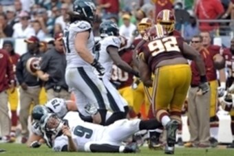 Sep 21, 2014; Philadelphia, PA, USA; Philadelphia Eagles quarterback Nick Foles (9) lies on the field after begin hit by Washington Redskins defensive end Chris Baker (92) at Lincoln Financial Field. The Eagles defeated the Redskins, 37-34. Mandatory Cred