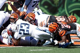 CINCINNATI, OH - SEPTEMBER 21:  Jayson DiManche #51 of the Cincinnati Bengals wraps up Shonn Greene #23 of the Tennessee Titans after Greene powers his way into the end zone to score a touchdown during the fourth quarter at Paul Brown Stadium on September