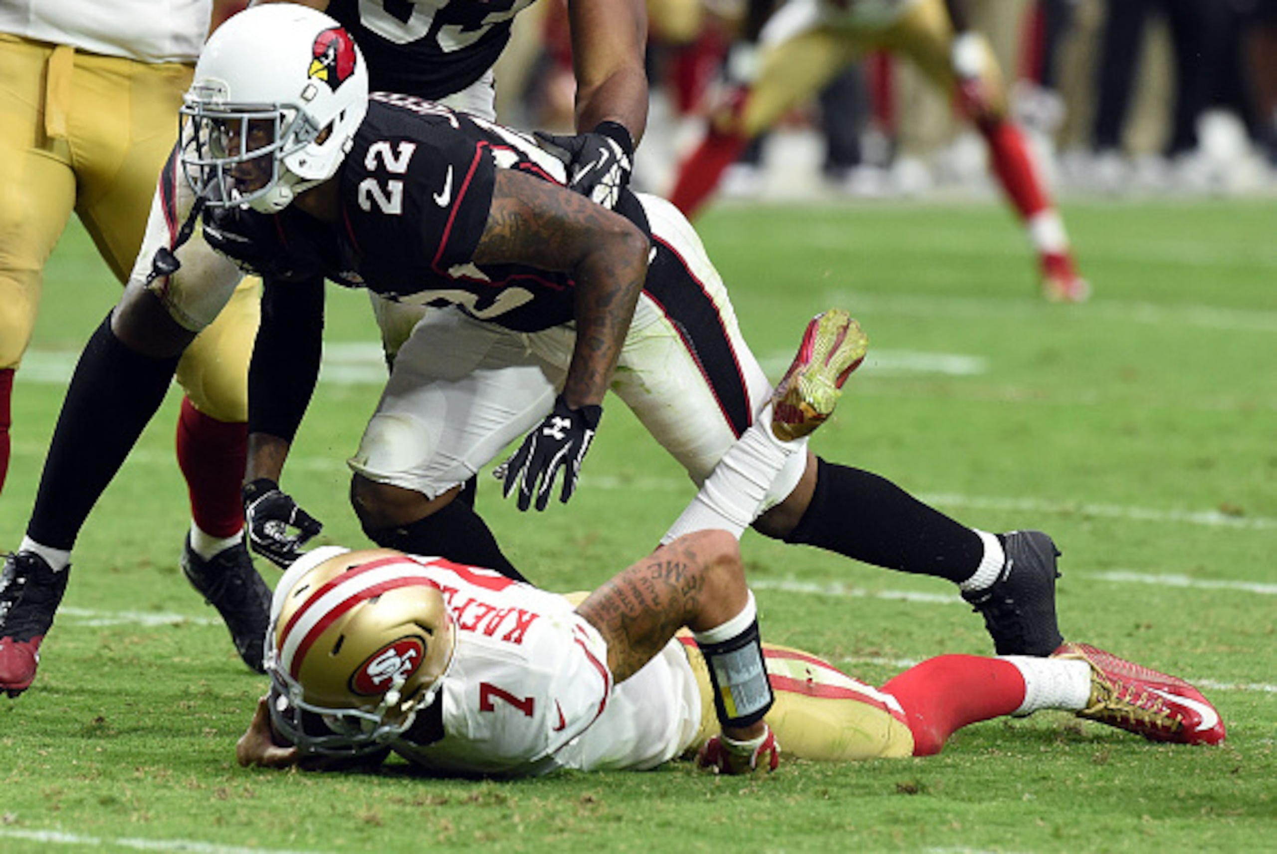GLENDALE, AZ - SEPTEMBER 21:  Quarterback Colin Kaepernick #7 of the San Francisco 49ers is hit by safety Tony Jefferson #22 of the Arizona Cardinals during the second half of NFL game at University of Phoenix Stadium on September 21, 2014 in Glendale, Ar