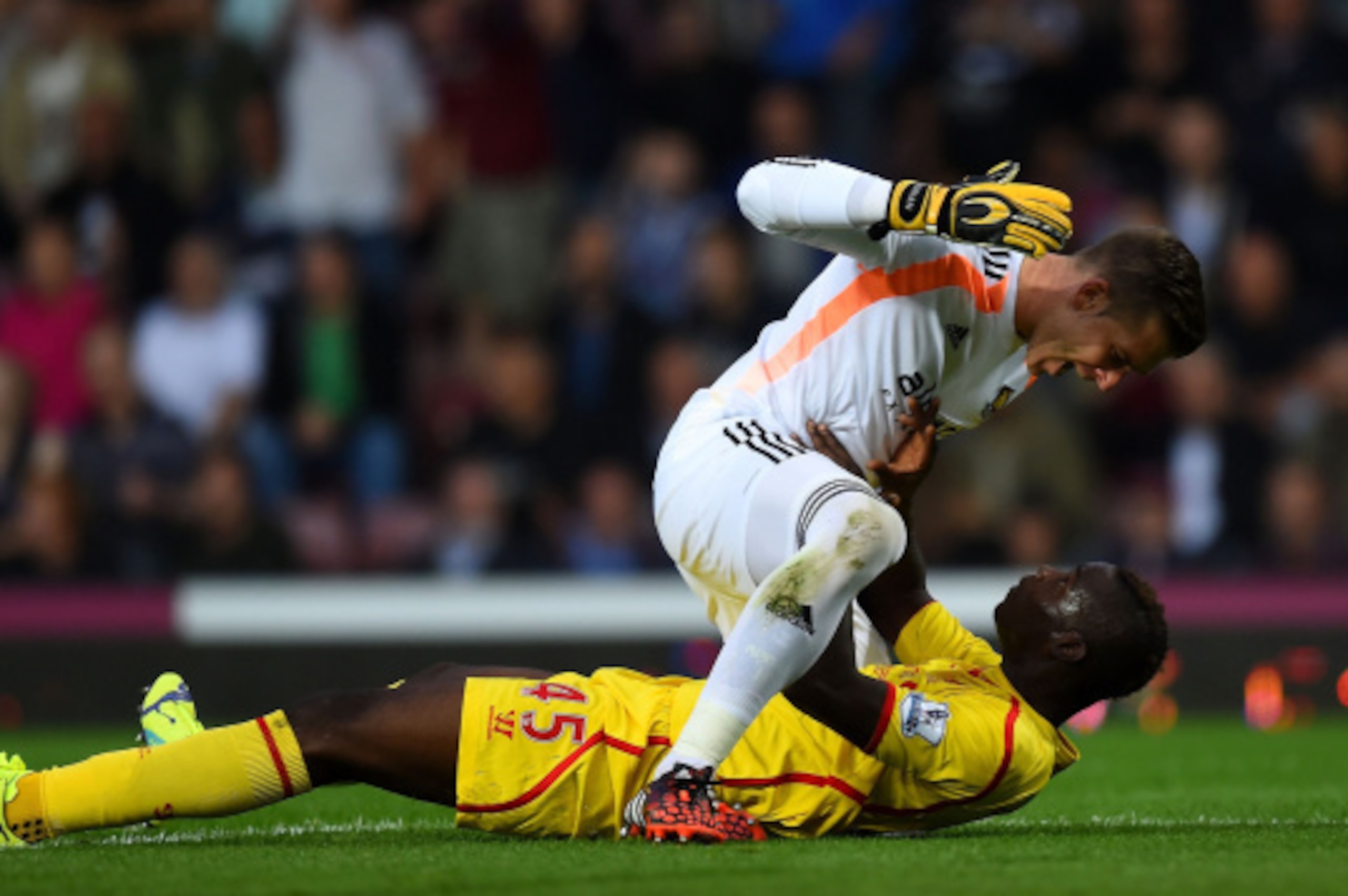 LONDON, ENGLAND - SEPTEMBER 20:  Mario Balotelli of Liverpool and Adrian of West Ham clash following a heavy tackle by Balotelli on Adrian during the Barclays Premier League match between West Ham United and Liverpool at Boleyn Ground on September 20, 201