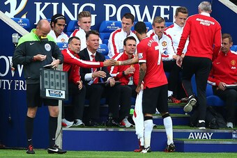 LEICESTER, ENGLAND - SEPTEMBER 21:  Angel di Maria of Manchester United shakes hands with Ryan Giggs the assisitant manager of Manchester United and Louis van Gaal the manager of Manchester United as he is substituted in the second half during the Barclay