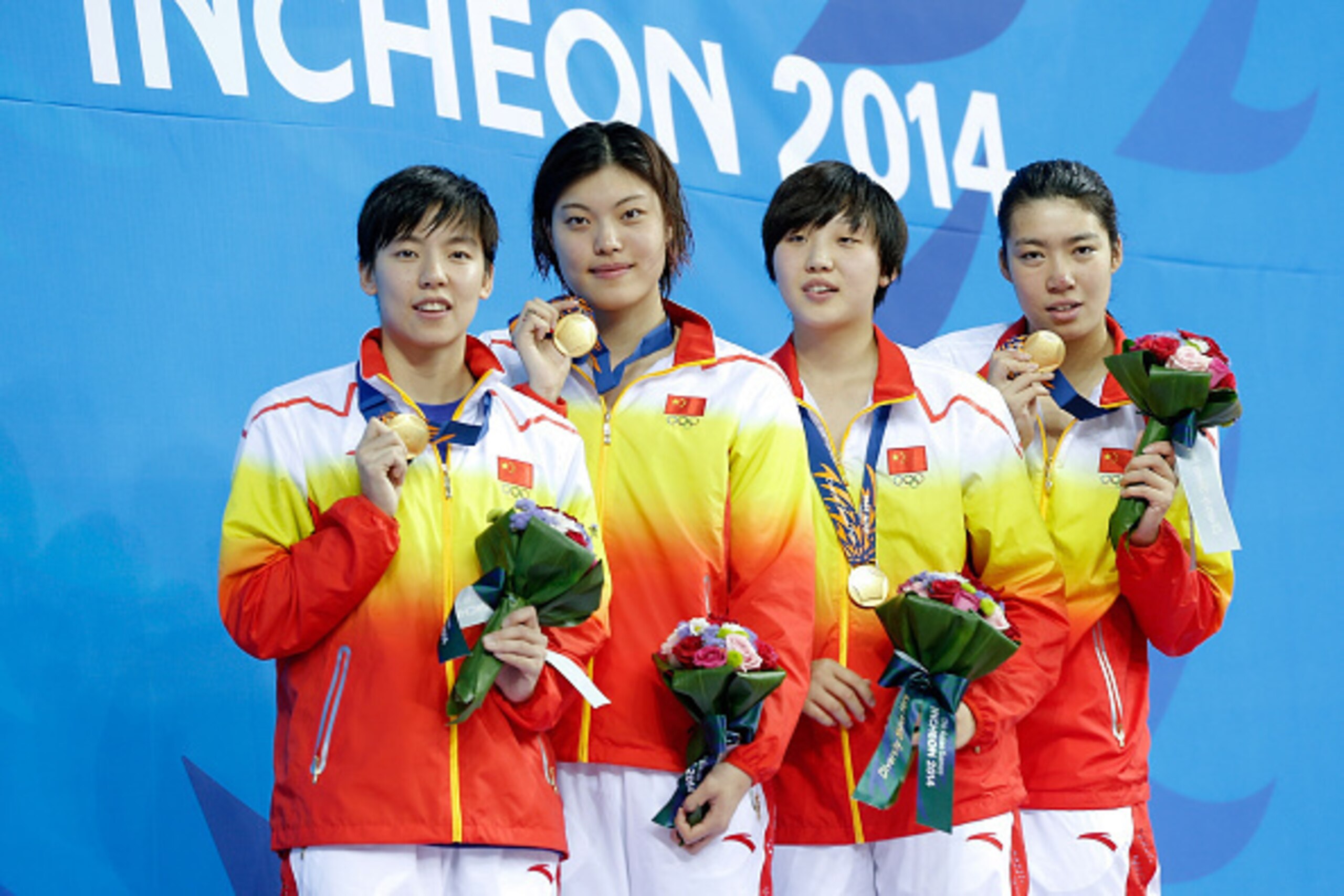 INCHEON, SOUTH KOREA - SEPTEMBER 23: Gold medalist Guo Junjun, Tang yi, Gao Yue And Shen Duo of China celebrate during the medal ceremony after the swimming Women's 4 x 200m Freestyle Relay Final during the day four of 2014 Asian Games at Munhak Park Tae-