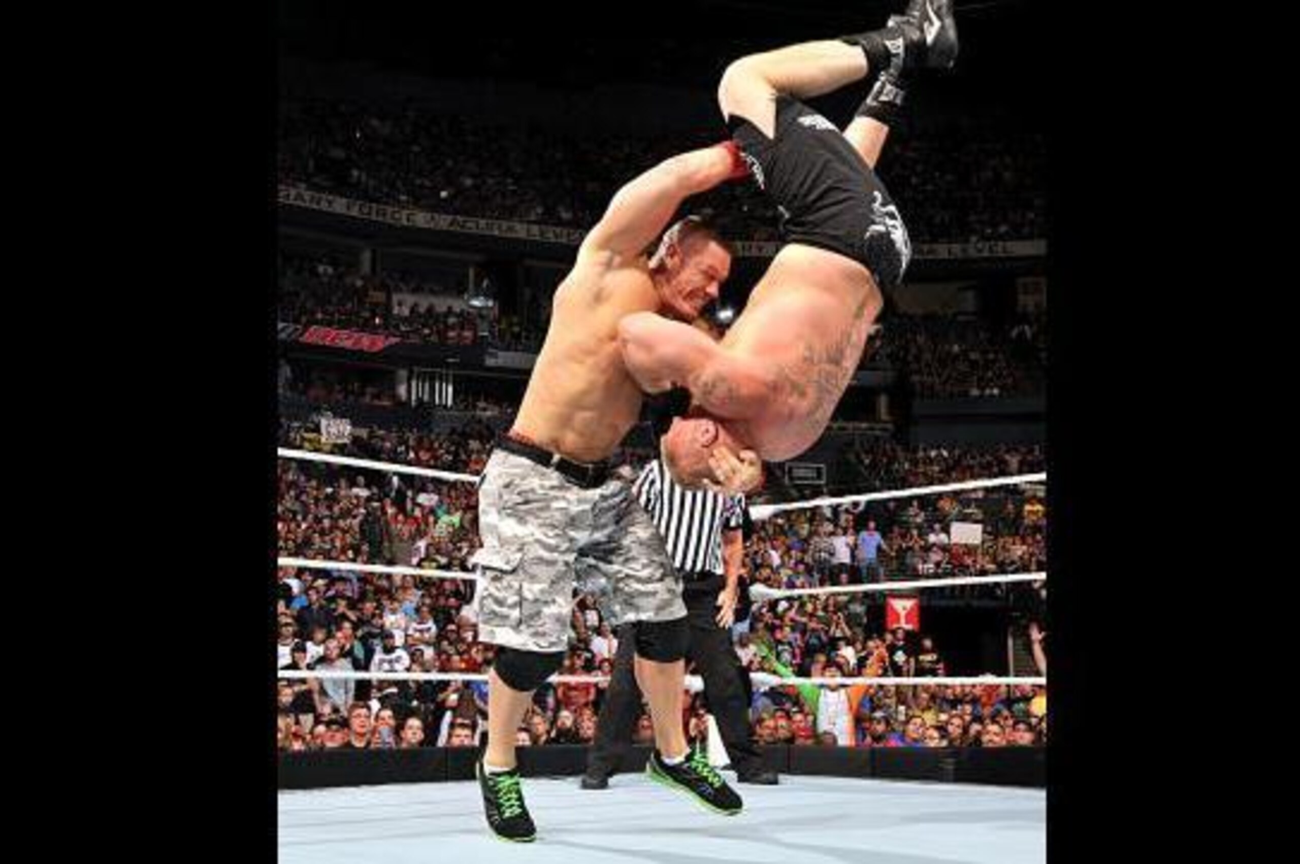 John Cena nails Brock Lesnar with the Attitude Adjustment.