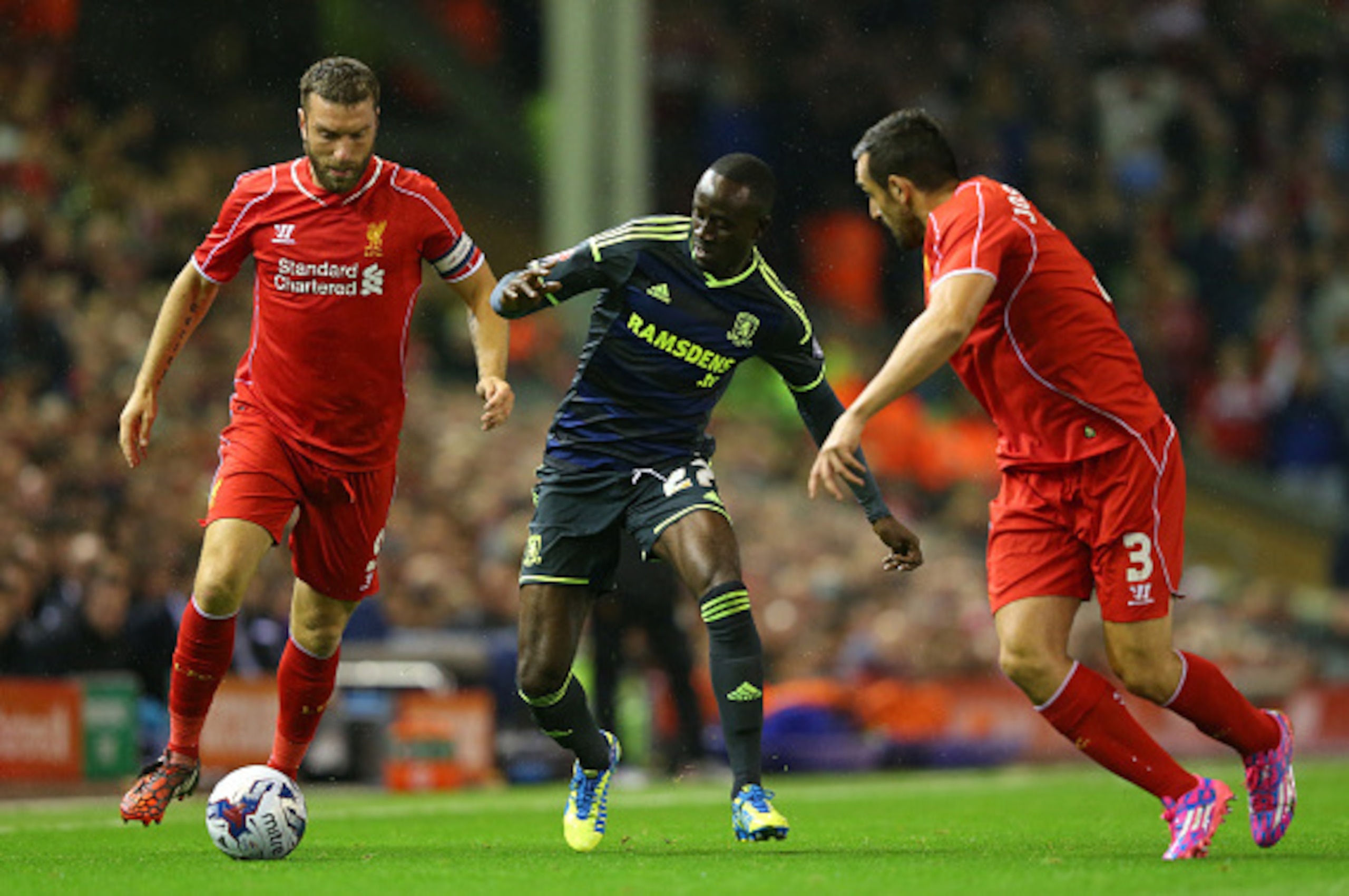 LIVERPOOL, ENGLAND - SEPTEMBER 23:  Albert Adomah of Middlesbrough takes on Rickie Lambert and Jose Enrique of Liverpool during the Capital One Cup Third Round match between Liverpool and Middlesbrough at Anfield on September 23, 2014 in Liverpool, Englan
