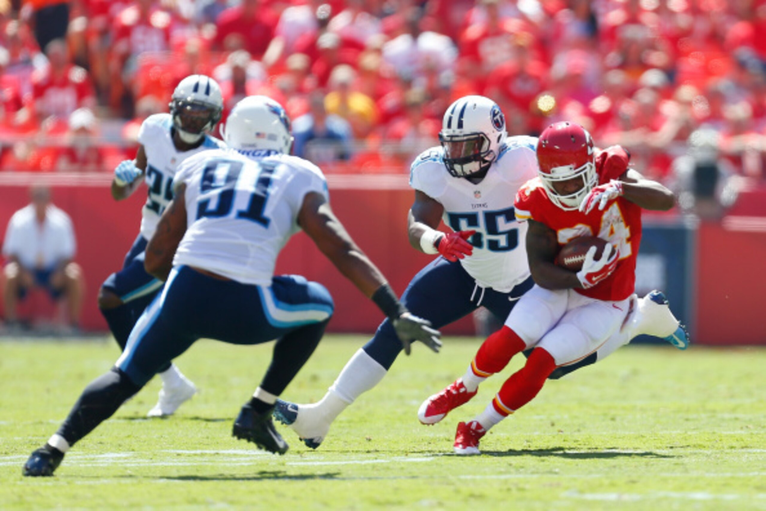 KANSAS CITY, MO - SEPTEMBER 07:  Kelcie McCray #24 of the Kansas City Chiefs runs the ball against Derrick Morgan #91 of the Tennessee Titans during the first quarter at Arrowhead Stadium on September 7, 2014 in Kansas City, Missouri.  (Photo by Wesley Hi