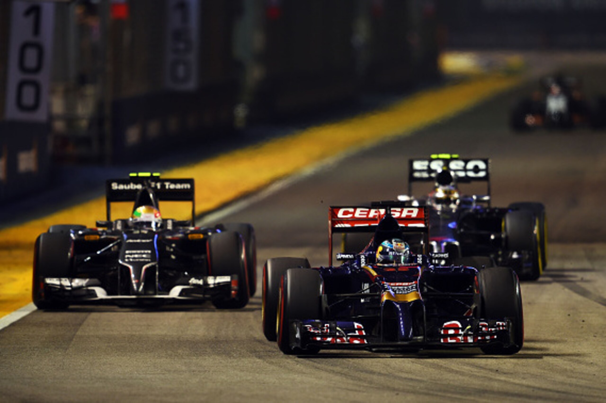 SINGAPORE - SEPTEMBER 21:  Jean-Eric Vergne of France and Scuderia Toro Rosso leads Esteban Gutierrez of Mexico and Sauber F1 during the Singapore Formula One Grand Prix at Marina Bay Street Circuit on September 21, 2014 in Singapore, Singapore.  (Photo b